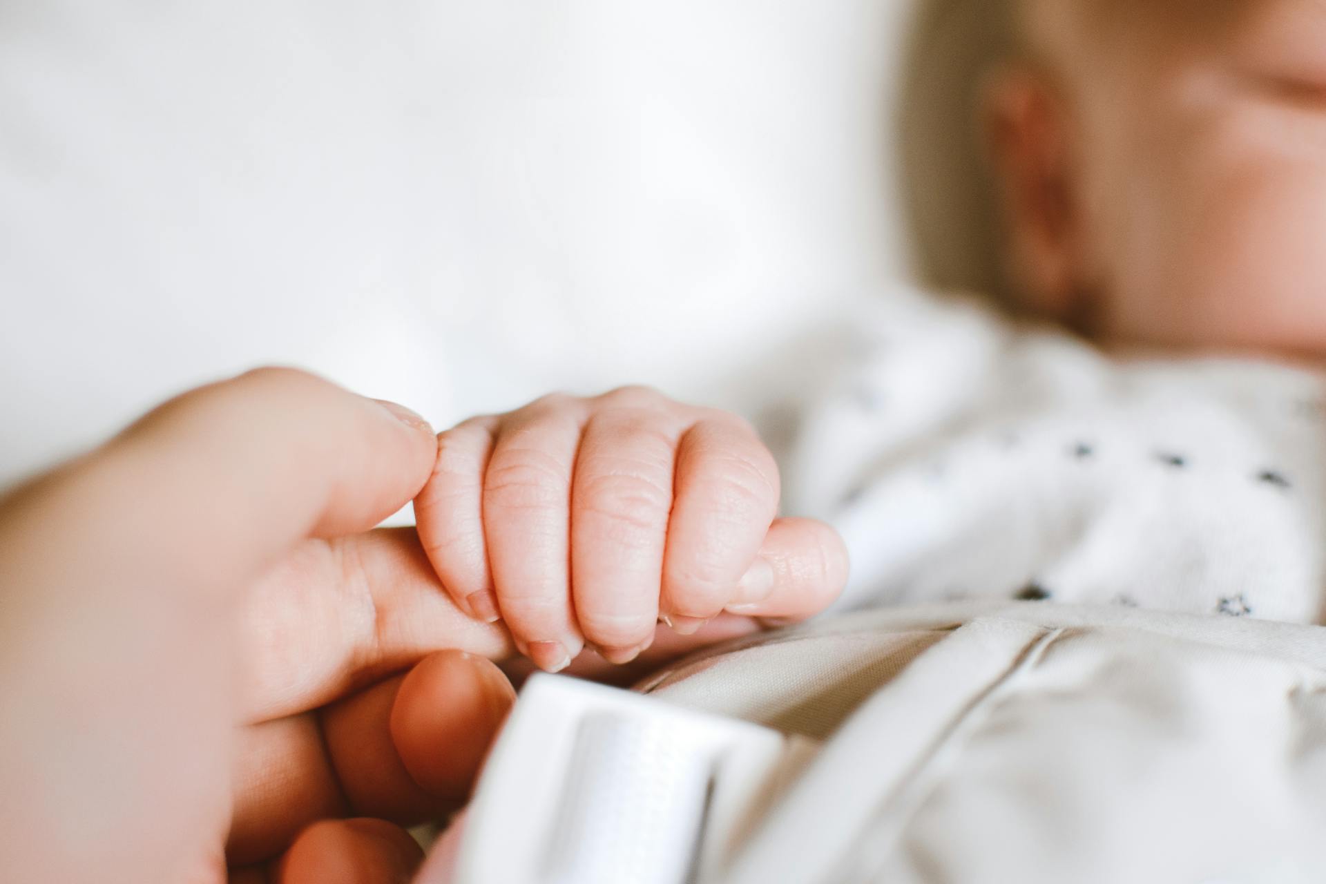 A baby holding a man's finger | Source: Pexels