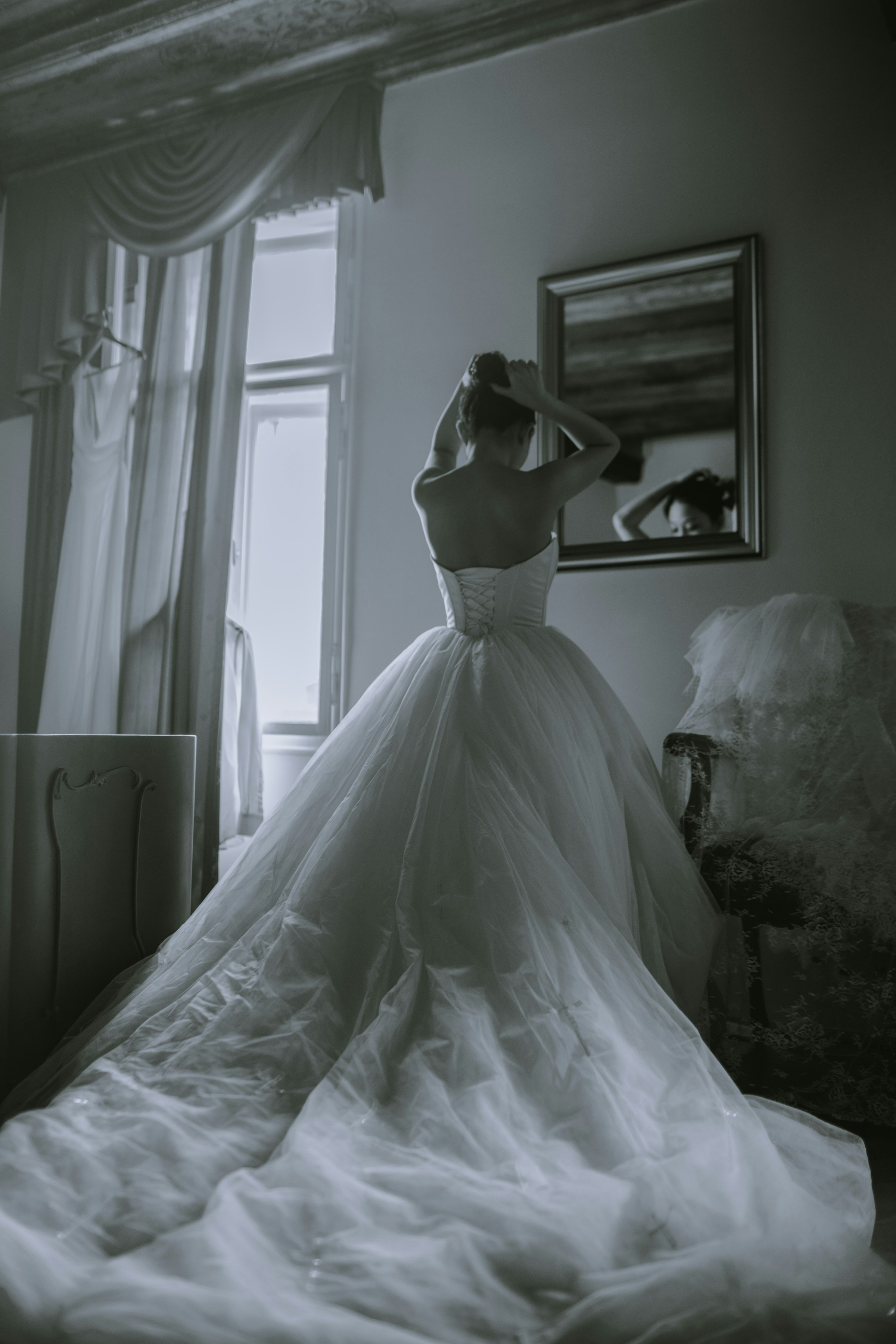 A woman in a pristine bridal gown looking at the mirror | Source: Unsplash