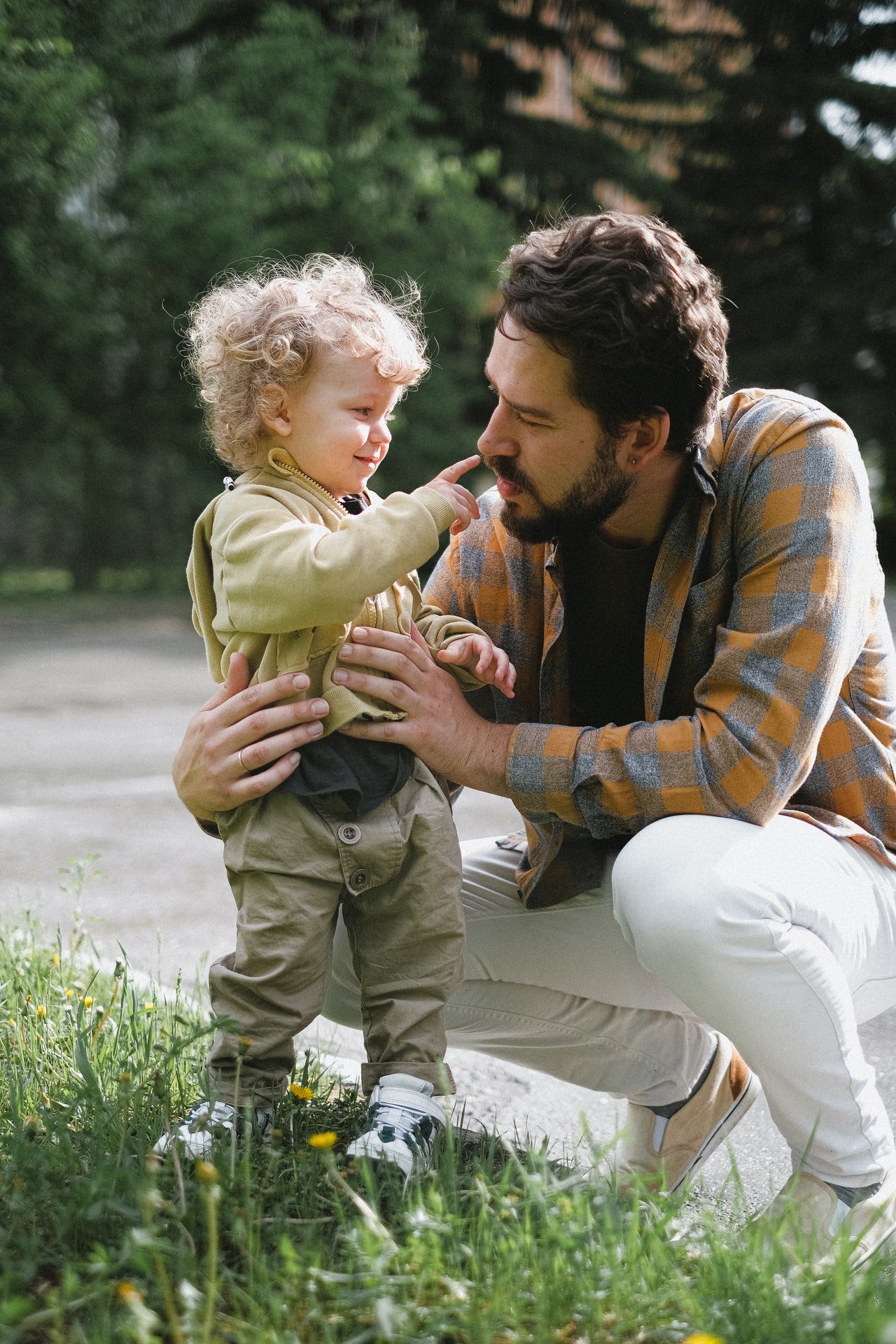 Photo of a father holding his child outside. | Source: Pexels/AnnaShvets
