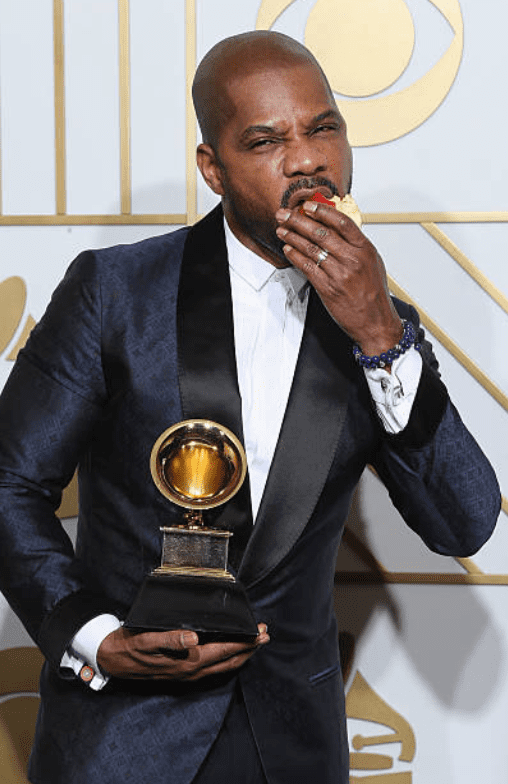 Kirk Franklin eats an apple while holding his award in the press room for the 58th GRAMMY Awards on February 15, 2016, in Los Angeles, California | Source: Frederick M. Brown/Getty Images