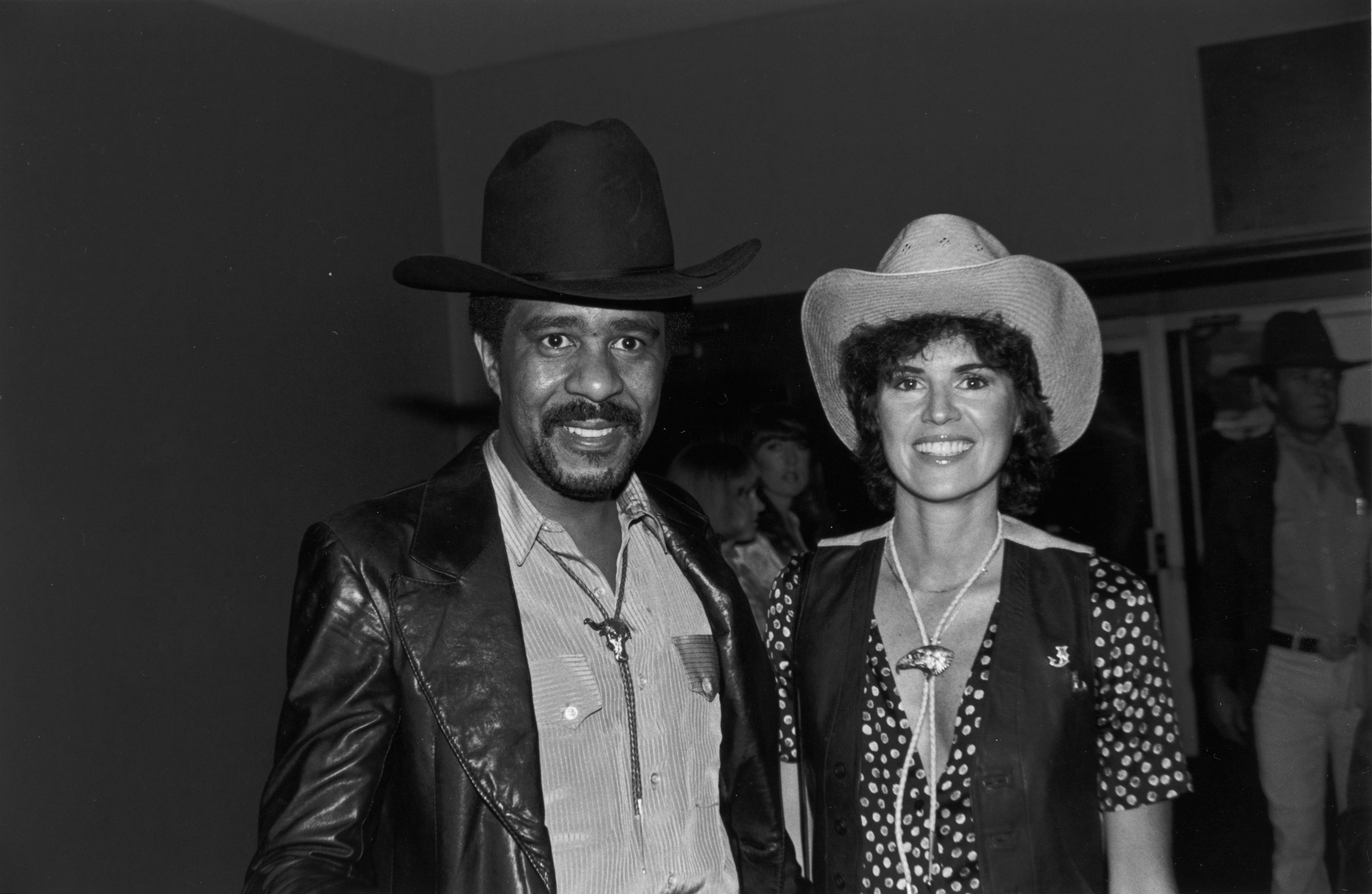 Richard Pryor and Jennifer Lee wearing cowboy hats and bolo ties, smile while at the annual SHARE party, held at the Hollywood Palladium, Hollywood, California. | Source: Getty Images