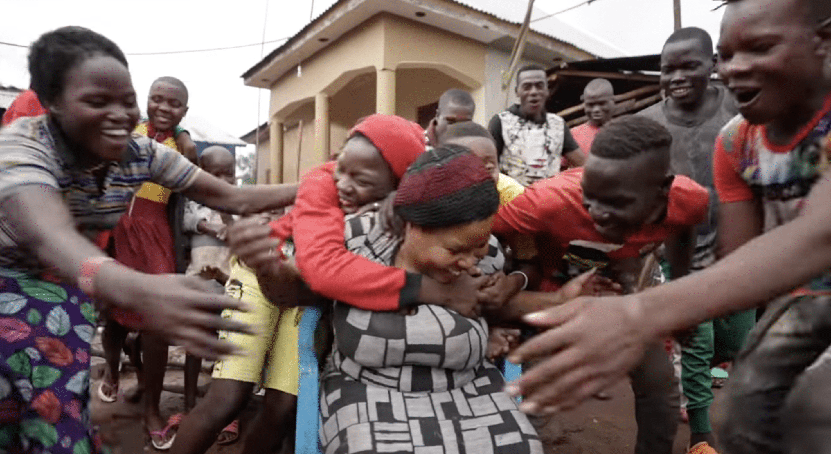 Nabatanzis riesige Brut hüllt sie in eine liebevolle Umarmung. | Quelle: YouTube.com/Connect With Uganda