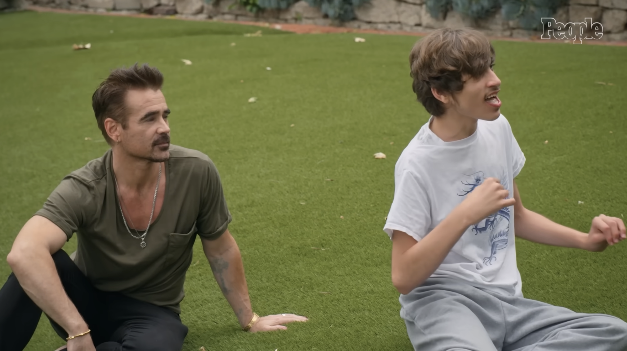Colin and James Farrell sit on the grass, from a post dated August 7, 2024. | Source: YouTube/ People