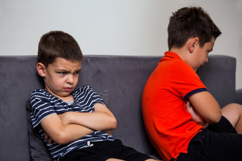 Niño enojado ignorando a su hermano después de una pelea. | Fuente: Shutterstock. Niño enojado ignorando a su hermano después de una pelea. | Fuente: Shutterstock.
