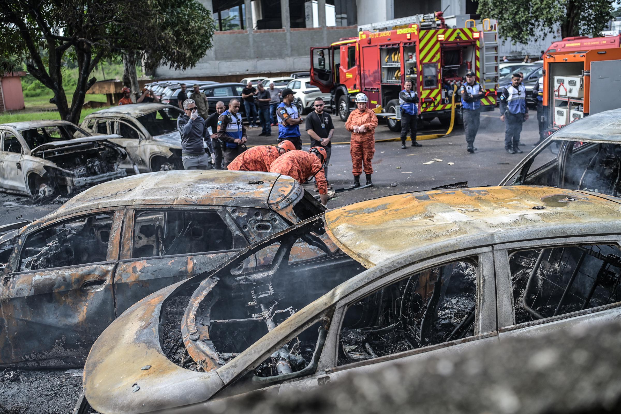 Emergency crews and investigators surveyed the damage after the helicopters crashed into a vehicle yard in Rio de Janeiro. Authorities said the impact sparked a fire that spread to about 20 cars. | Source: Getty Images