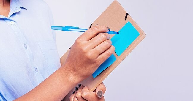 A nurse holds her clipboard during check-up. | Source: Shutterstock