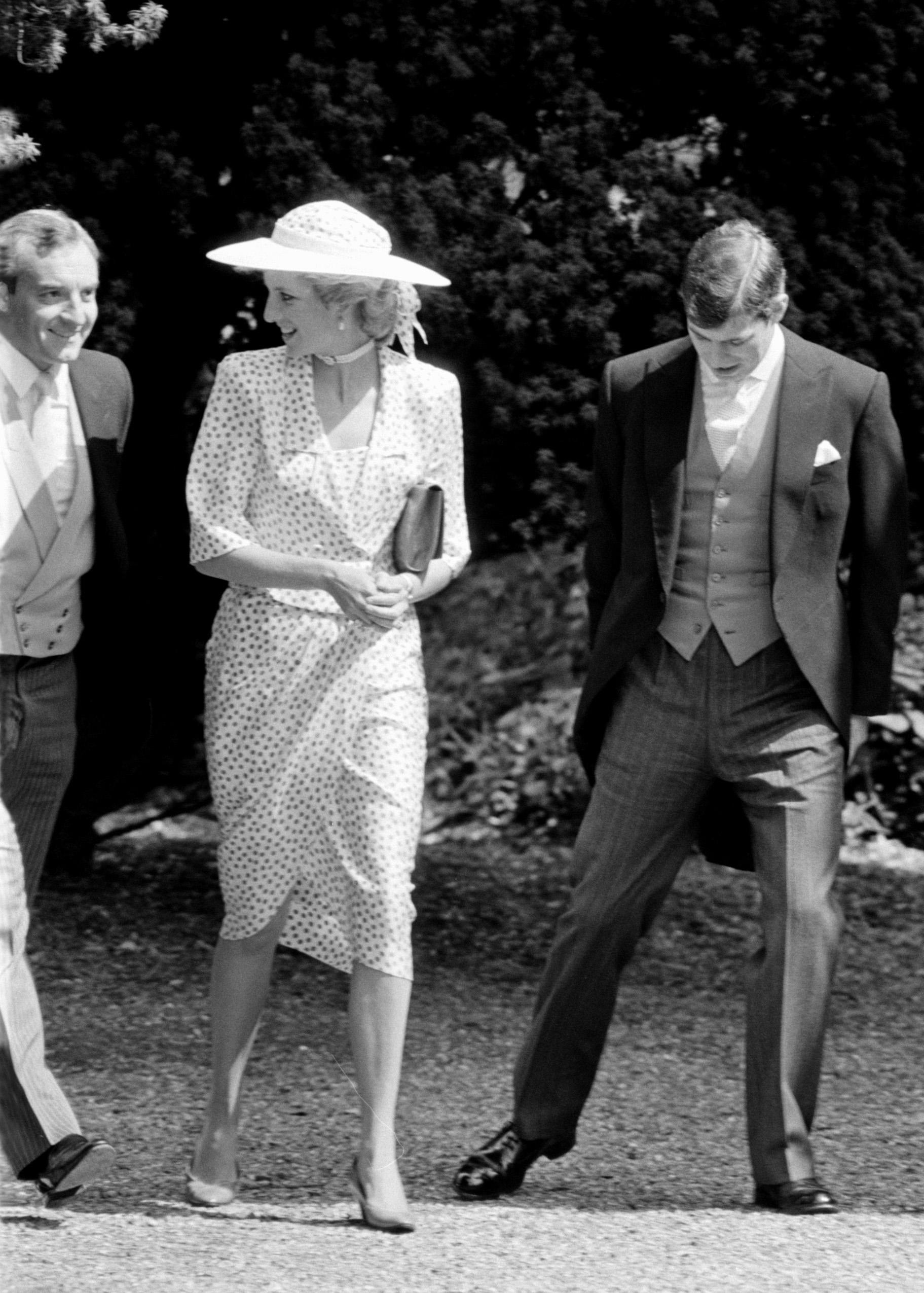 The Princess of Wales, wearing a pink spotted silk suit and brimmed white hat, smiles at her police bodyguard, Barry Mannakee, as she arrives at Highclere, Berkshire. | Source: Getty Images