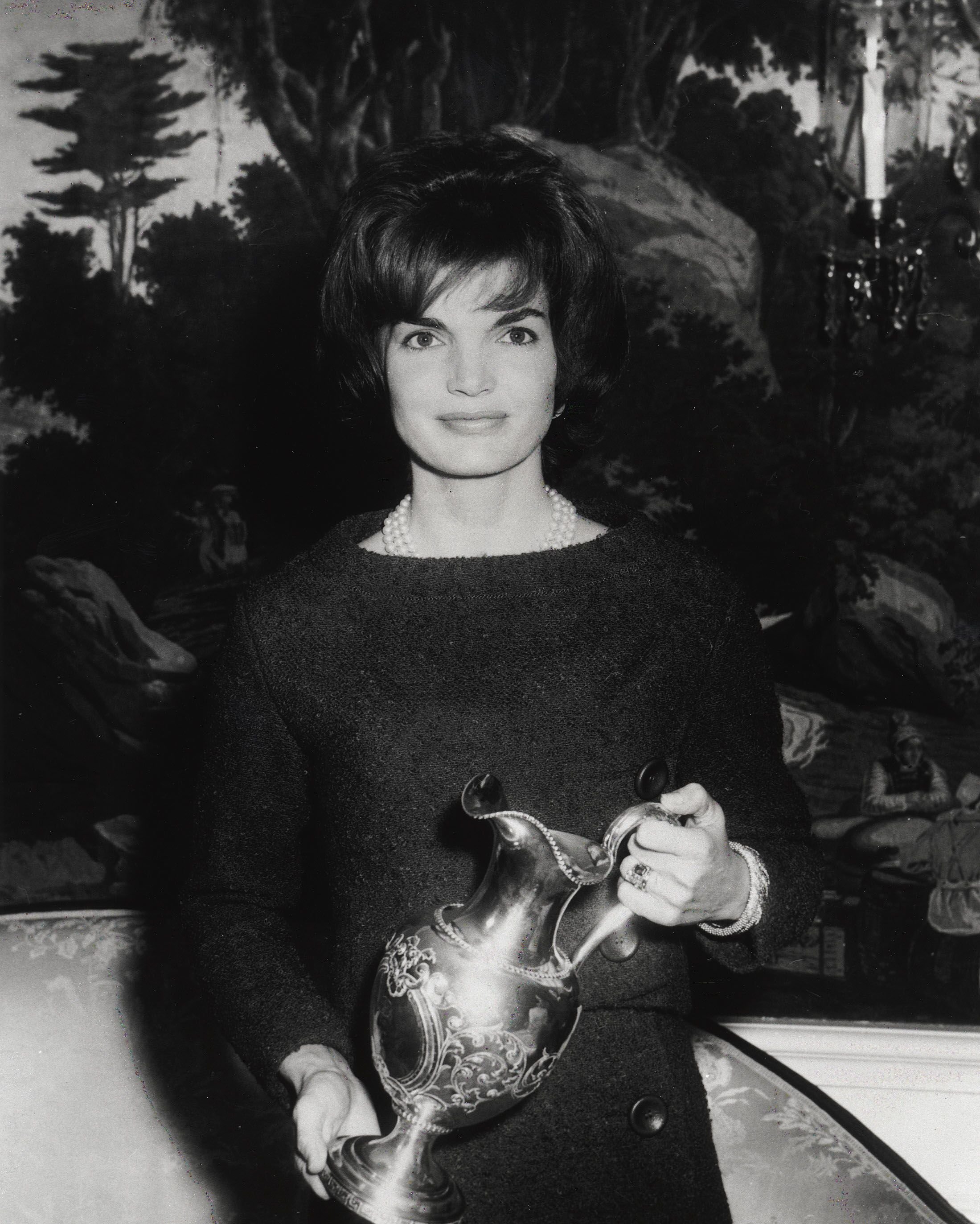 Jacqueline "Jackie" Kennedy pose pour une photo en tenant un cadeau en 1961 à la Maison Blanche à Washington, D.C. | Photo : Getty Images