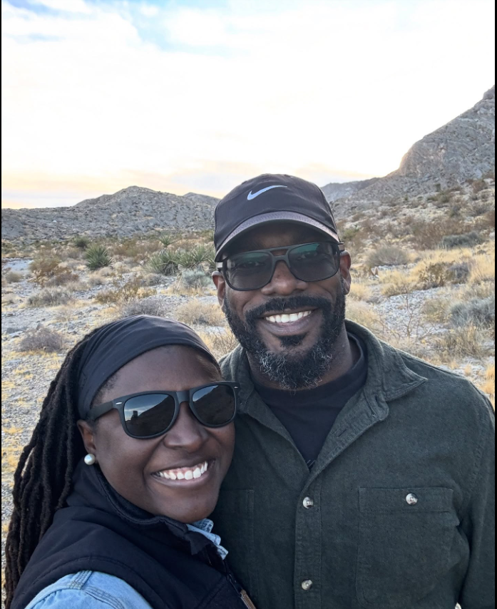 Smiling side by side during an outdoor getaway, Nancy Metayer Bowen and her husband Stephen Bowen pose for a relaxed selfie against a scenic desert backdrop, their casual attire and matching sunglasses capturing a candid, joyful moment together. | Source: Facebook/Nancy Metayer Bowen