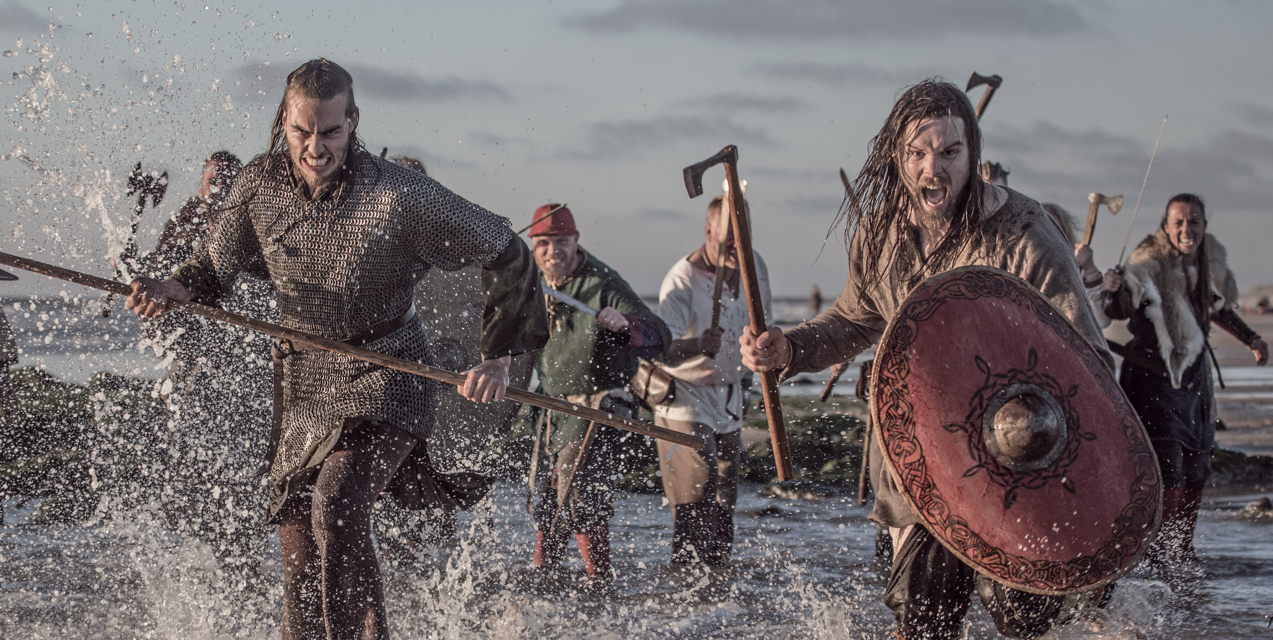 A group of Viking warriors wielding weapons in a battlefield scene at sea. | Source: Getty Images