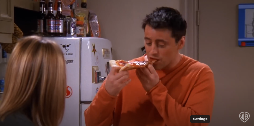 Matt LeBlanc as Joey on the set of "Friends" eating pizza | Source: YouTube/@warnerbrostv