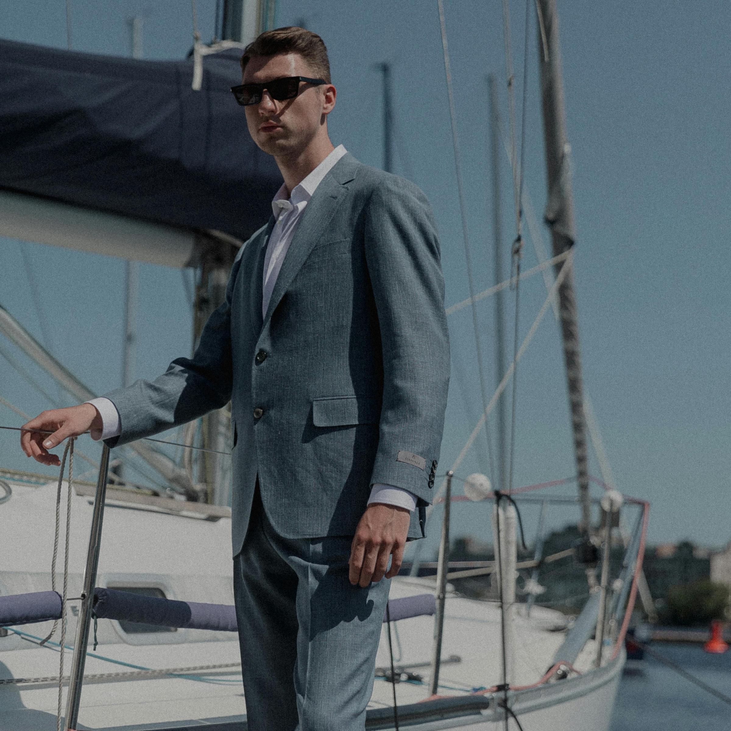 A smartly-suited man standing on a yacht jetty | Source: Pexels