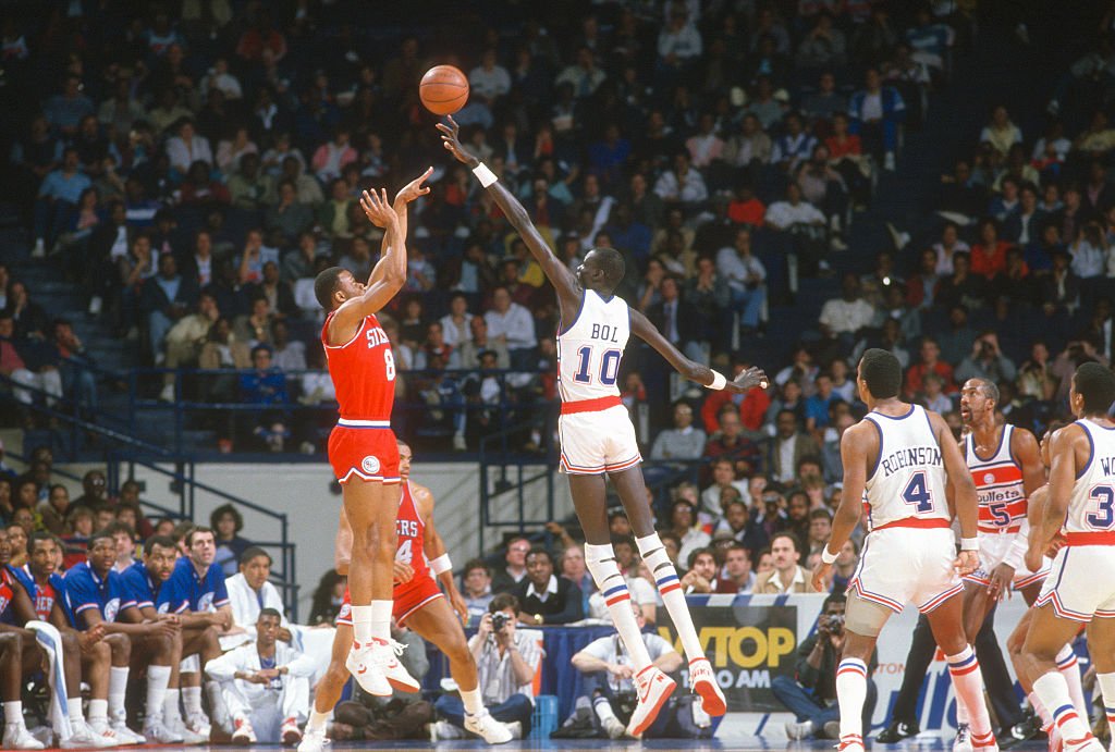 Manute Bol playing for the Washington Bullets blocking Michael Young's shot at the Capital Centre in Landover, Maryland in 1986 | Photo: Getty Images 