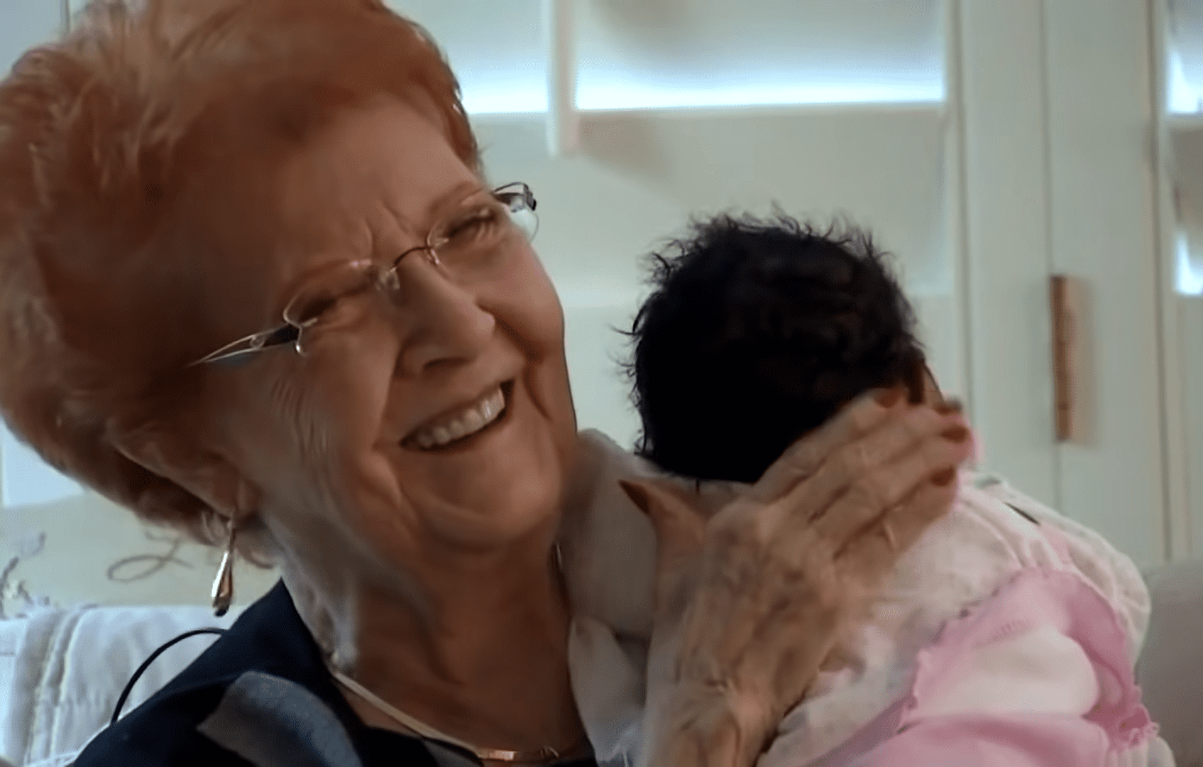 Joy Ringhofer holding the newborn and laughing. │Source: youtube.com/Inside Edition