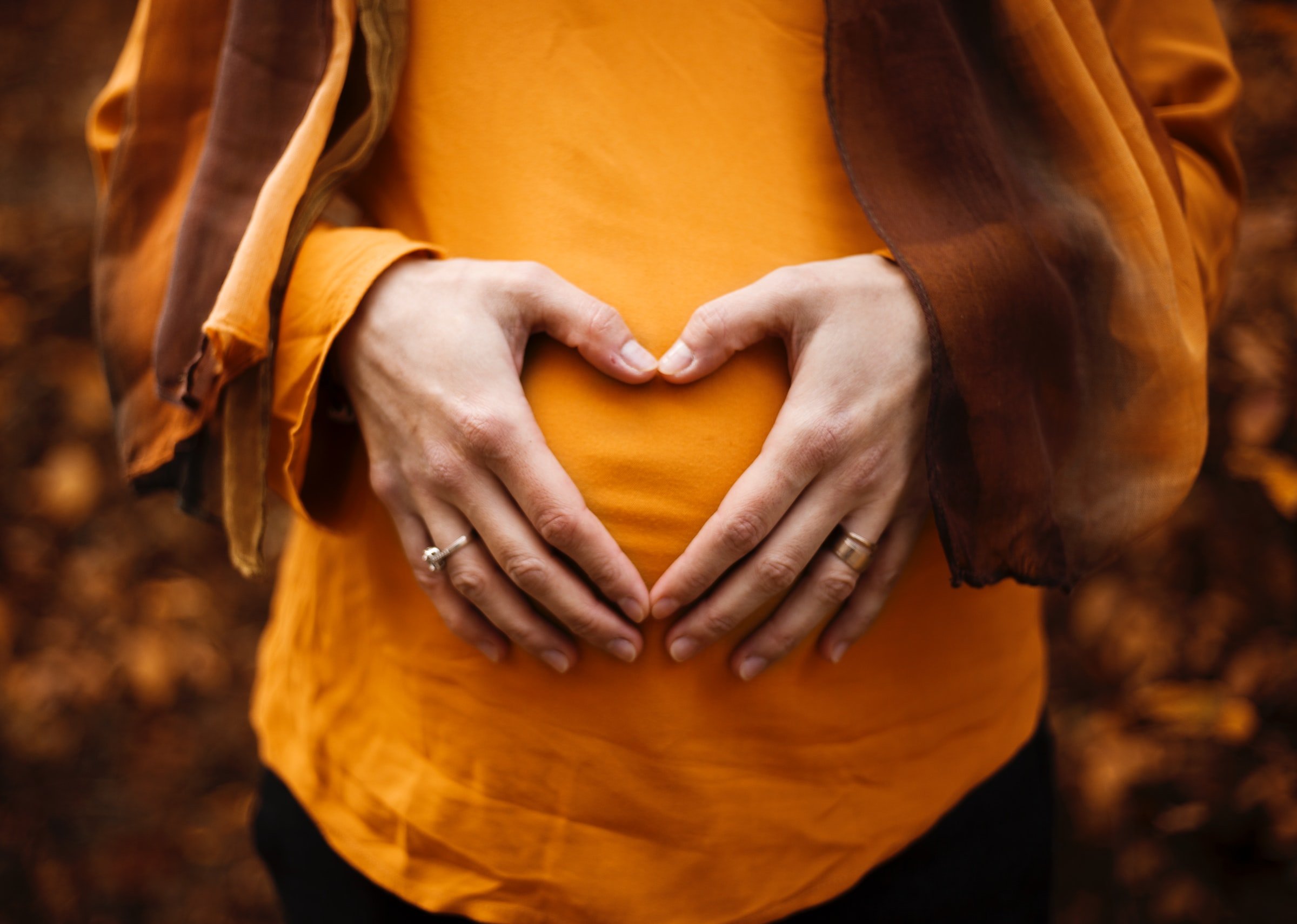 Schwangere Frau mit Händen auf ihrem Babybauch. | Quelle: Unsplash
