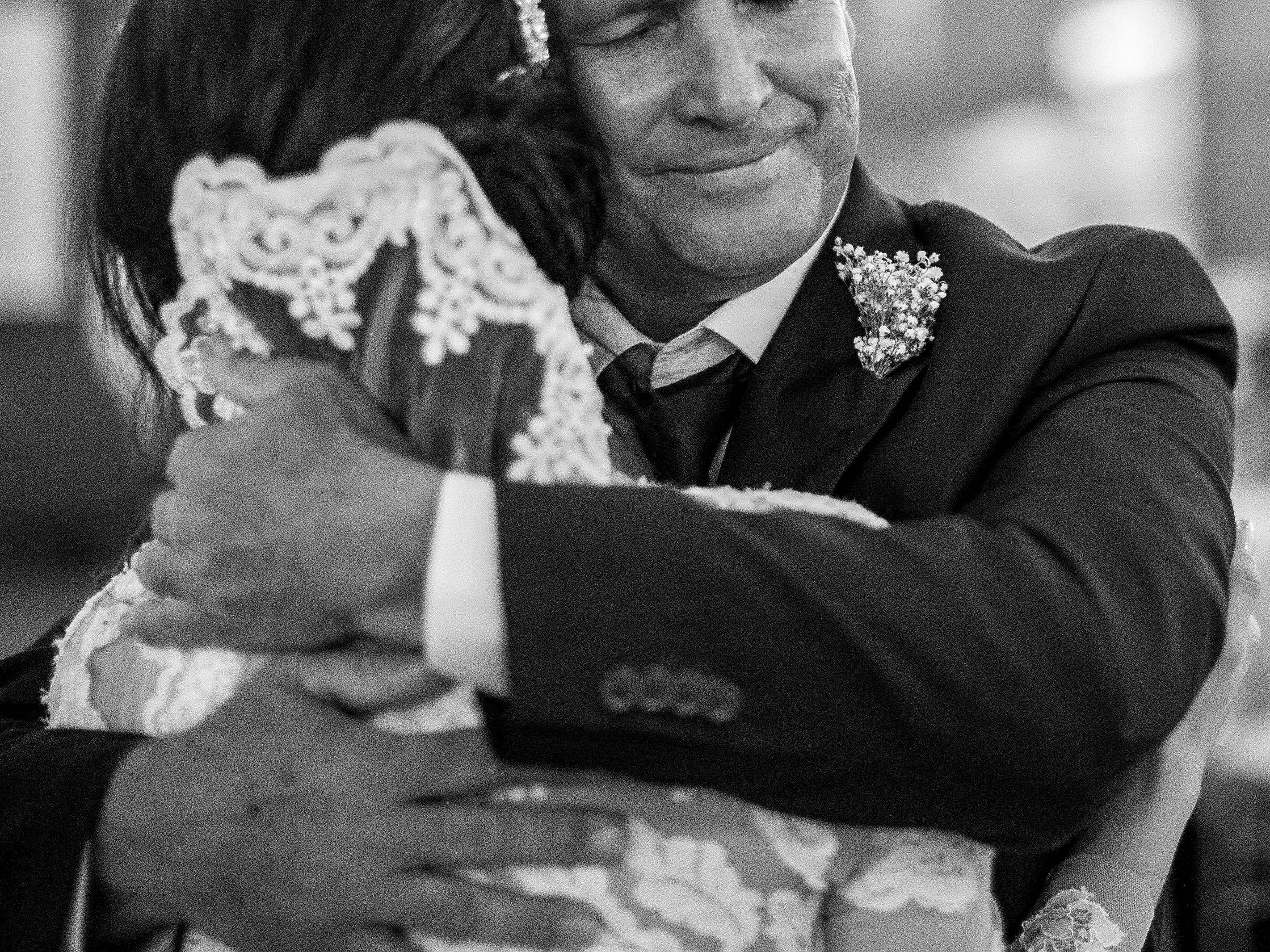 An elderly man hugging a bride | Source: Pexels