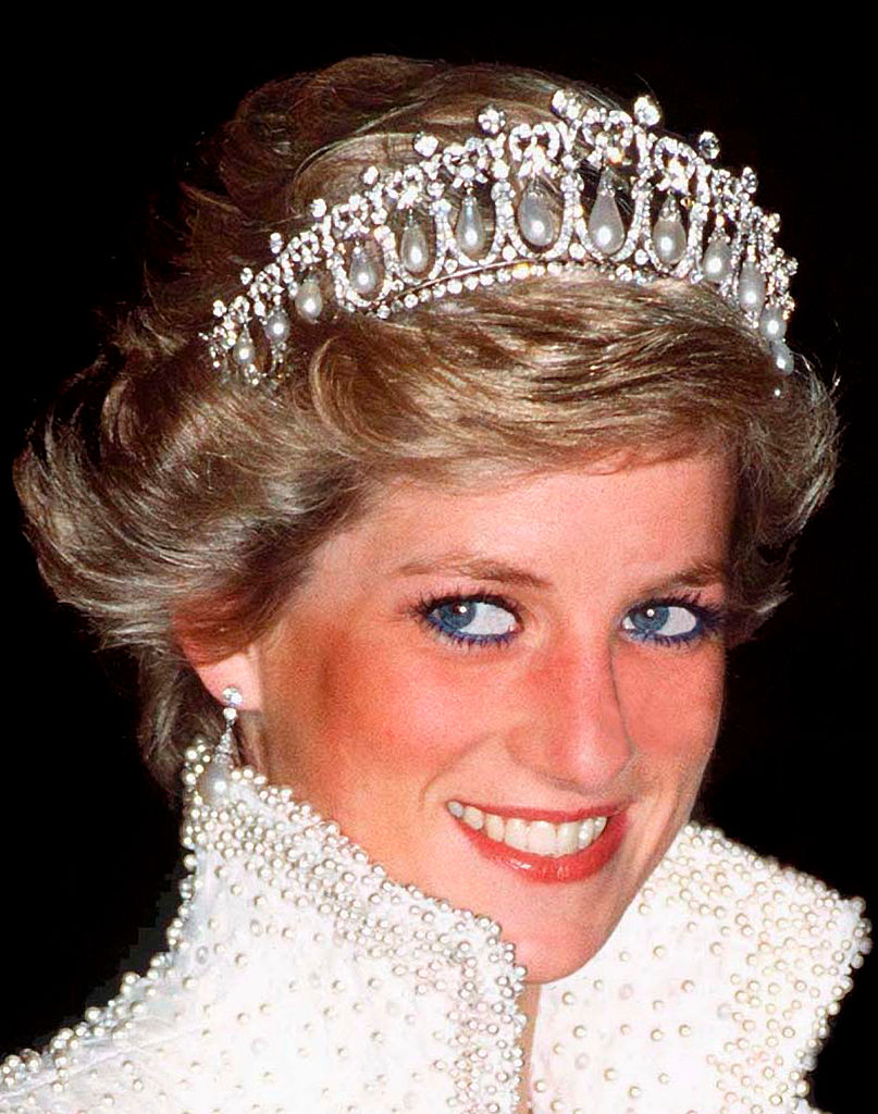 All eyes are on Princess Diana as she dazzles in a pearl-and-diamond tiara during a 1989 engagement in Hong Kong. Wearing a shimmering pearl-embellished gown — a symbol of her unrivaled elegance — she once again confirms her title as a global style icon.
