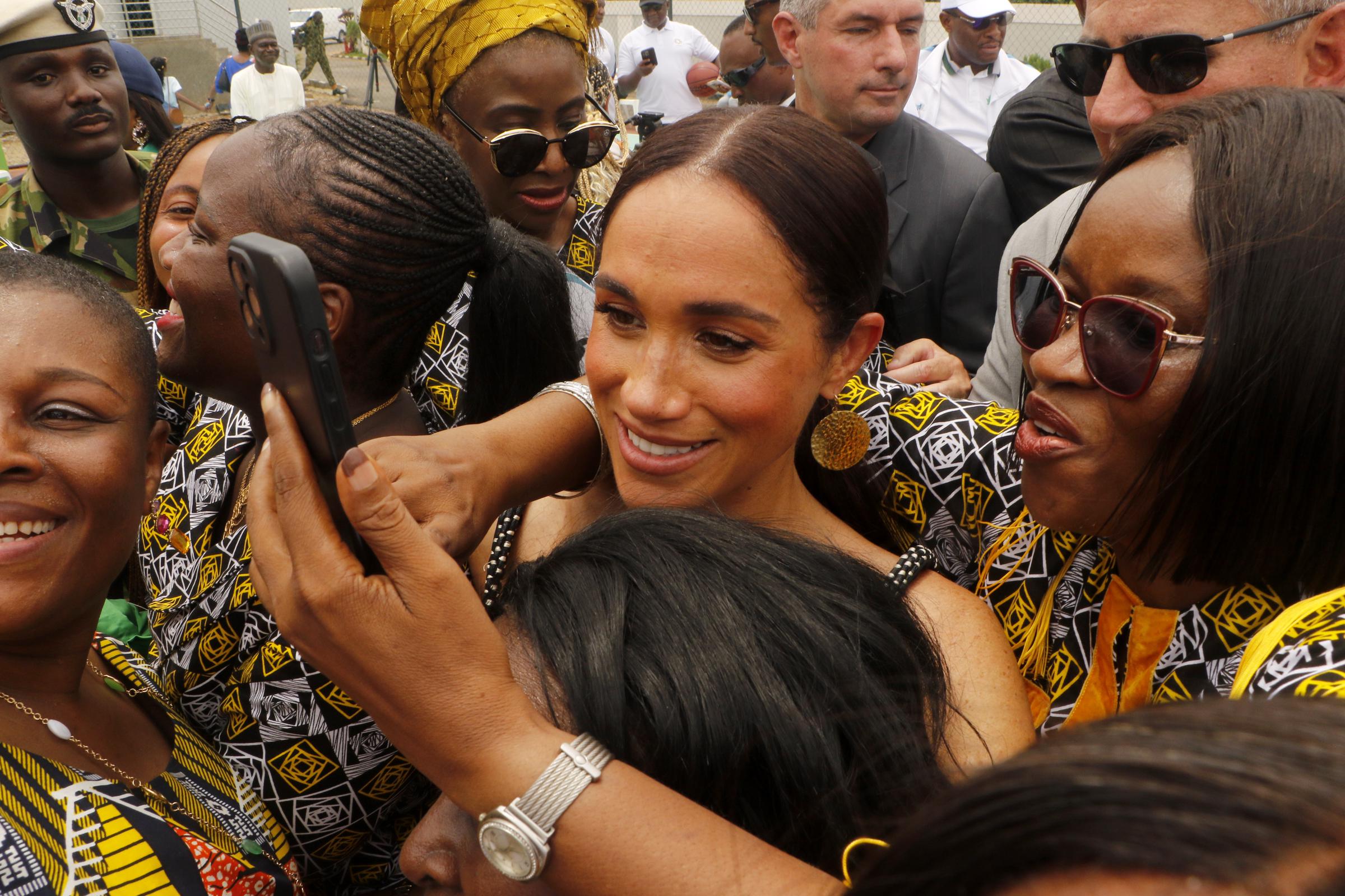 Meghan Markle smiles as she is surrounded by a crowd at a sitting volleyball match in Abuja, Nigeria, on May 11, 2024 | Source: Getty Images