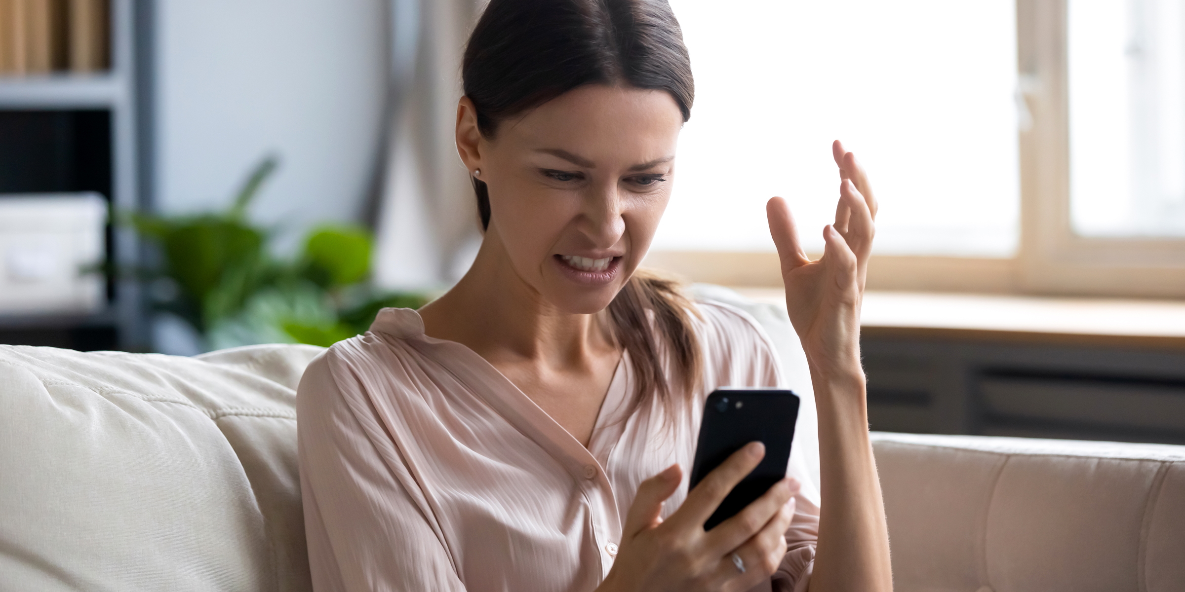 Angry woman with a smartphone | Source: Shutterstock