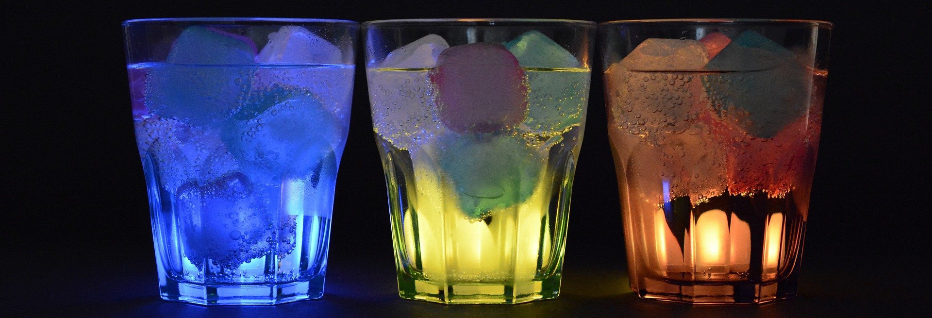Three glasses with ice lit up in different colors. | Photo: Pixabay/anncapictures 