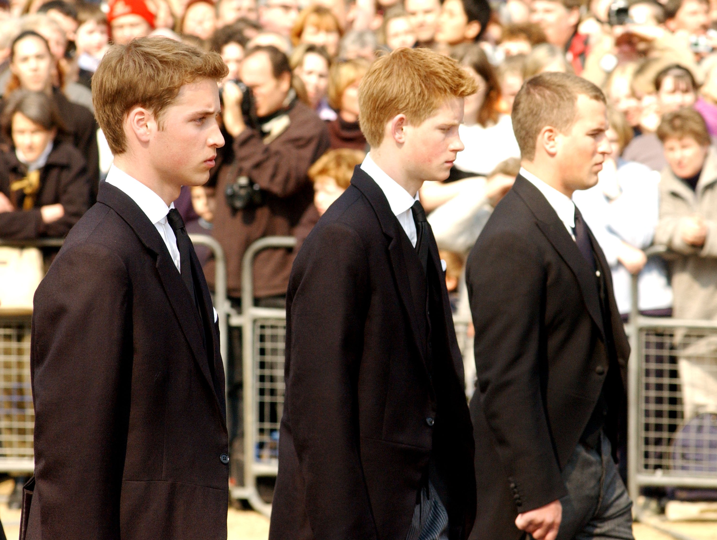 Prince William, Prince Harry, and Peter Phillips walk behind the coffin bearing the Queen Mother April 5, 2002 as her ceremonial procession makes its way down the Mall in London | Source: Getty Images