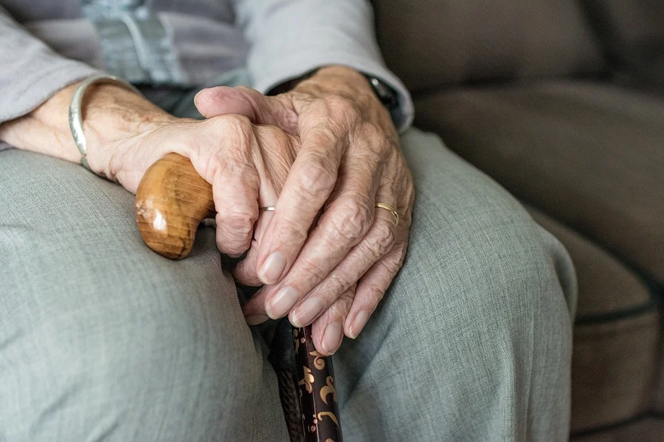 Anciana sosteniendo un bastón mientras está sentada en un sofá. | Foto: Pixabay Anciana sosteniendo un bastón mientras está sentada en un sofá. | Foto: Pixabay