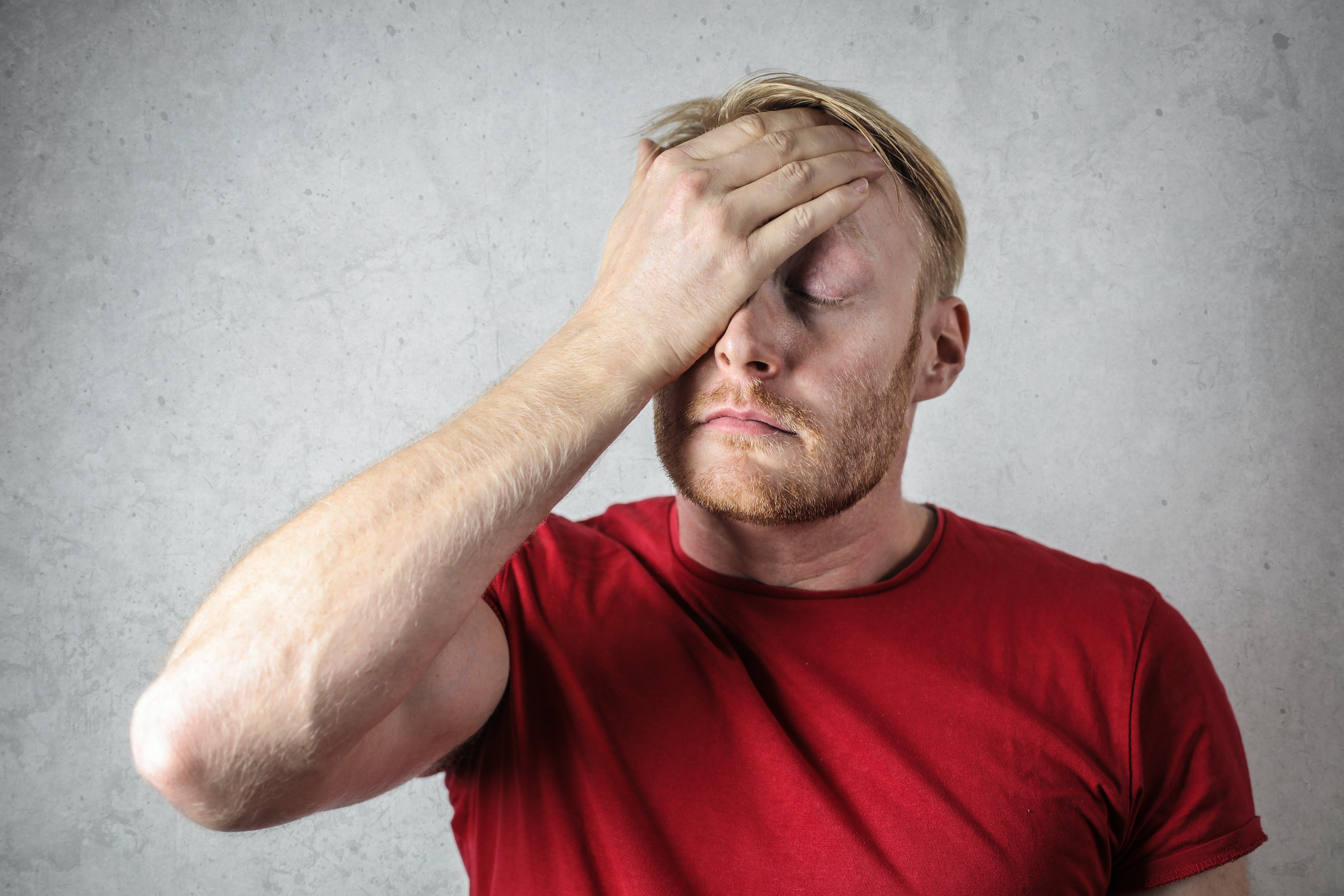 A stressed-out man with his hand on his face | Source: Pexels