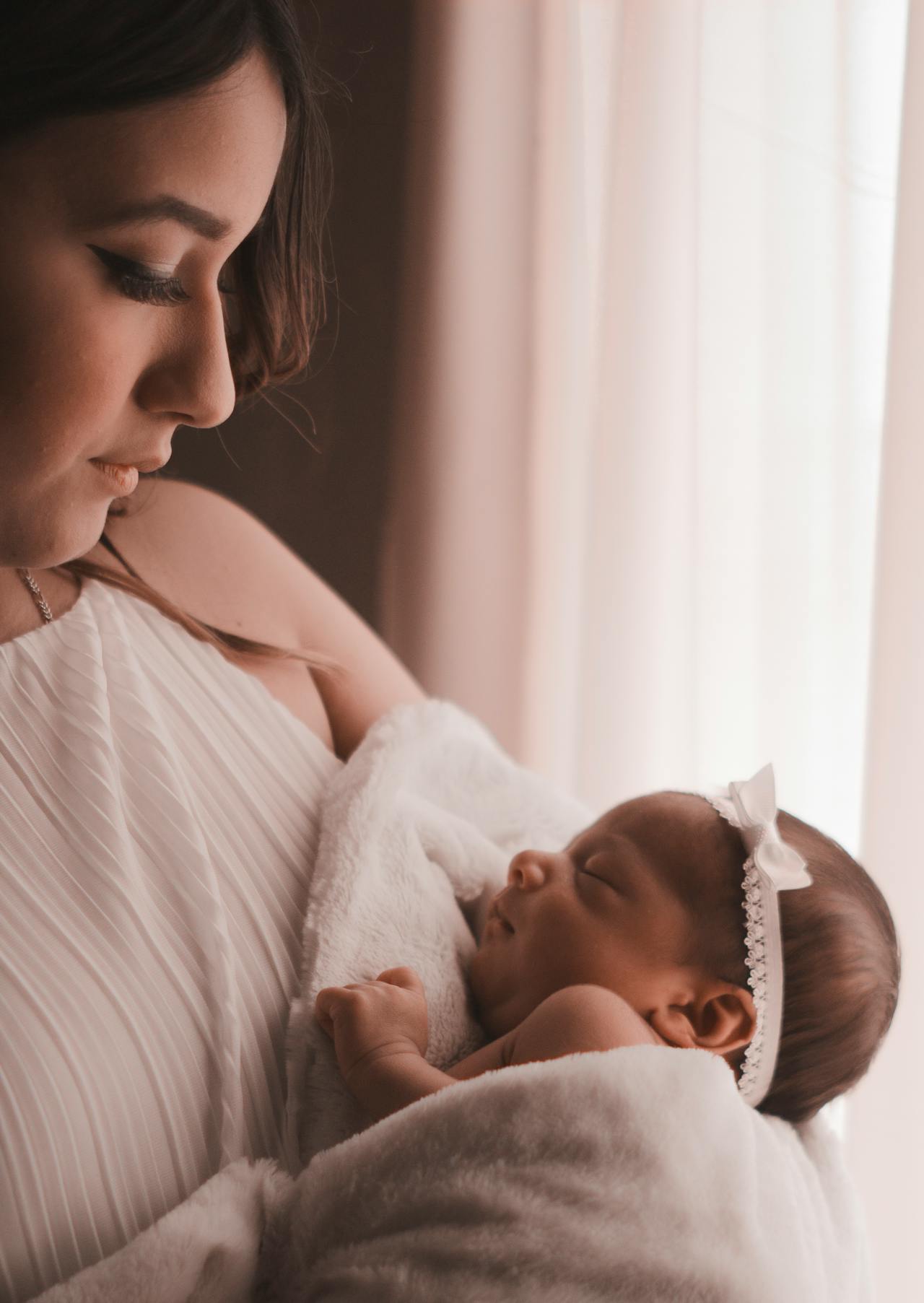 A woman holding a newborn baby girl | Source: Pexels