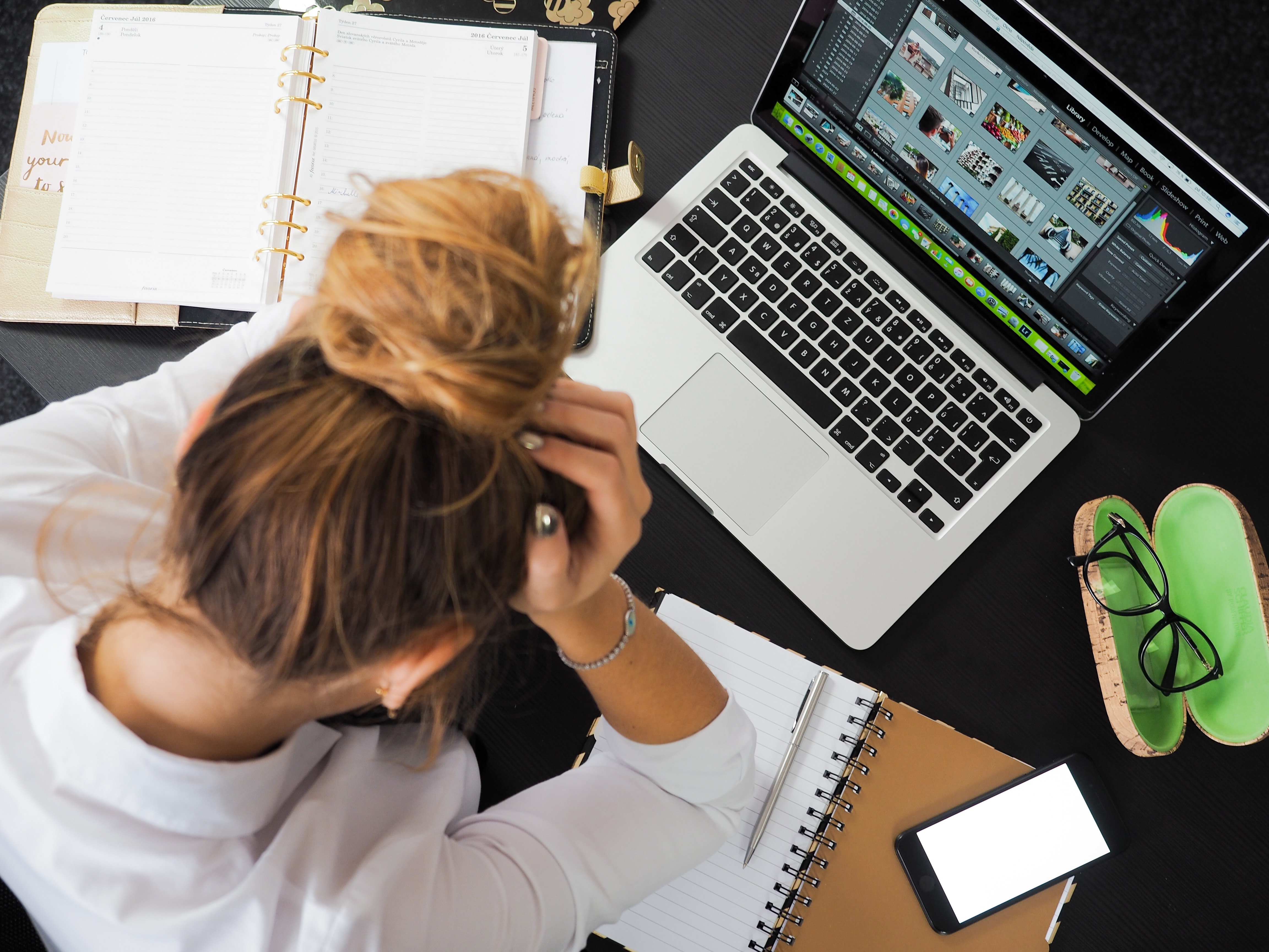 A woman sitting with her head in her hand infront of a computer | Source: Pexel/energepic.com