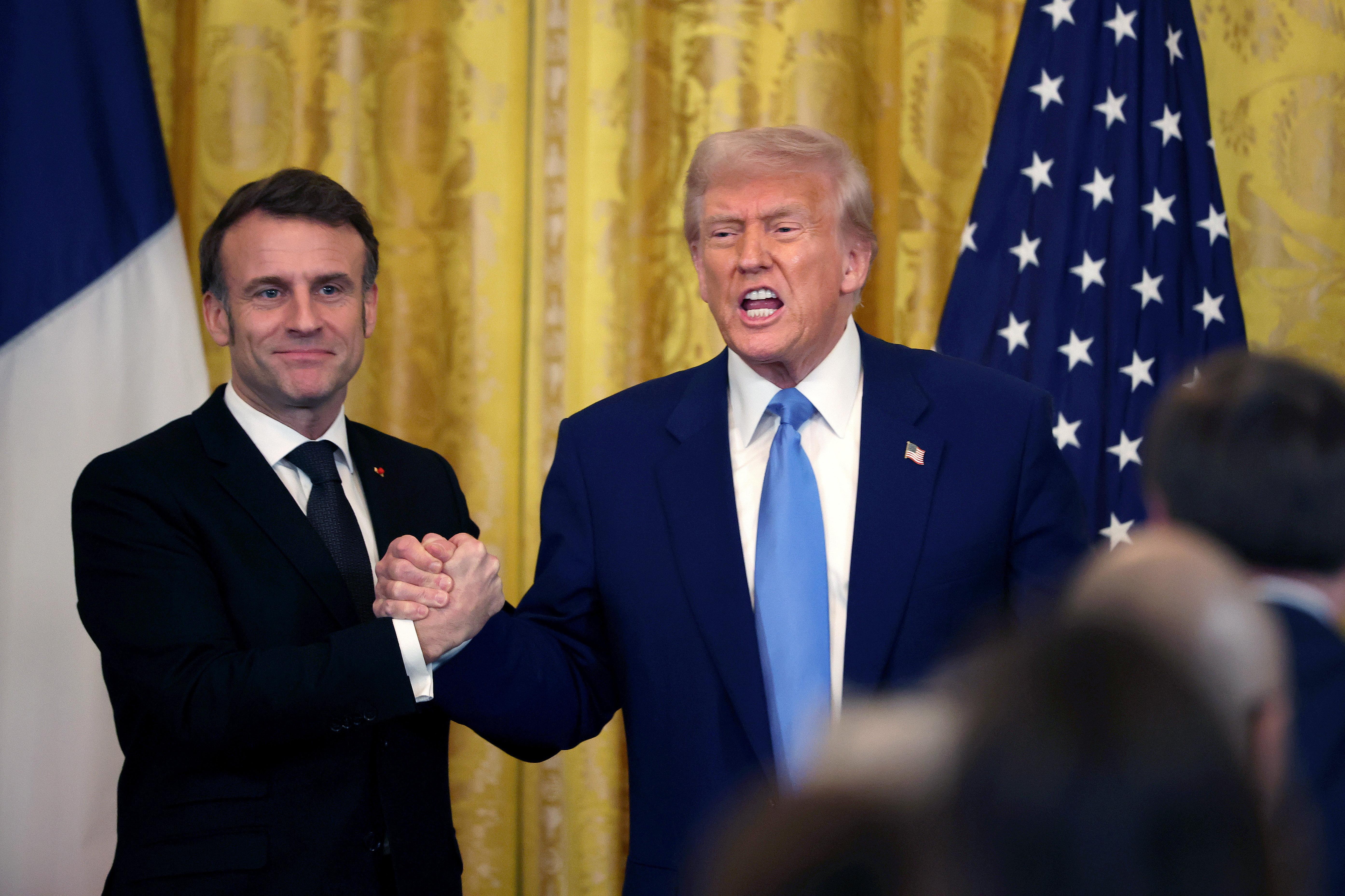 Emmanuel Macron shaking hands with Donald Trump as Trump addresses reporters during their meeting. | Source: Getty Images