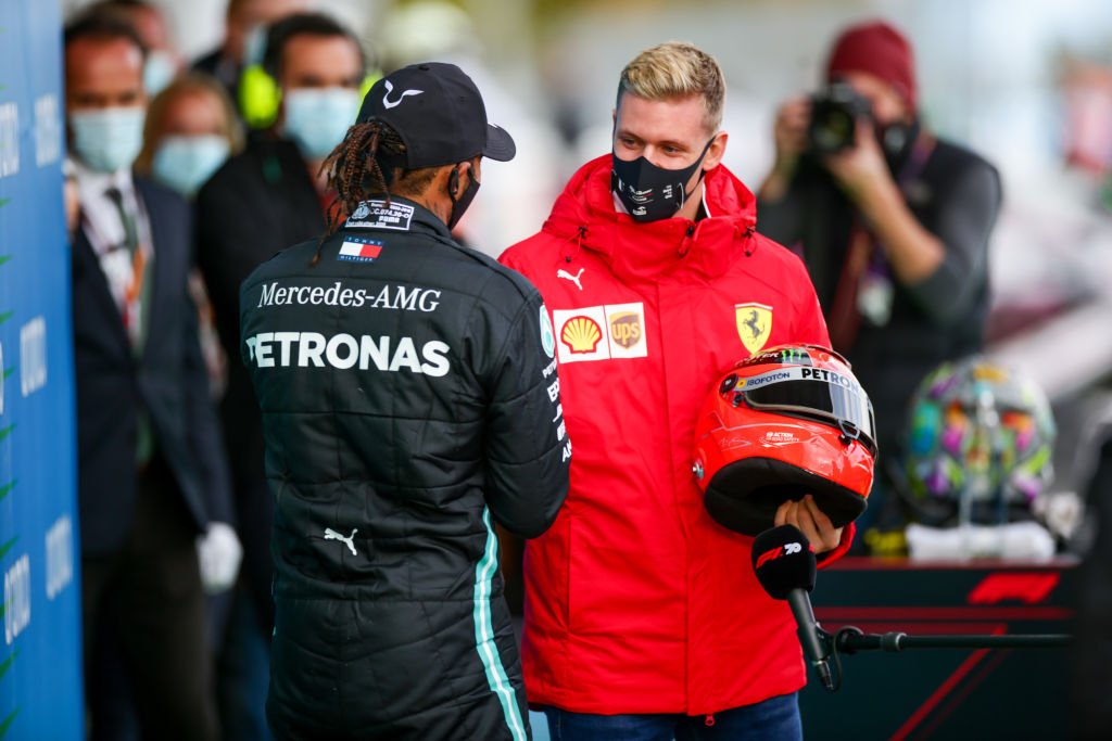 Mick Schumacher überreicht Lewis Hamilton den Helm seines Vaters Michael Schumacher während des F1 Eifel Grand Prix am 11. Oktober 2020 auf dem Nürburgring in Nürburg. | Quelle: Getty Images