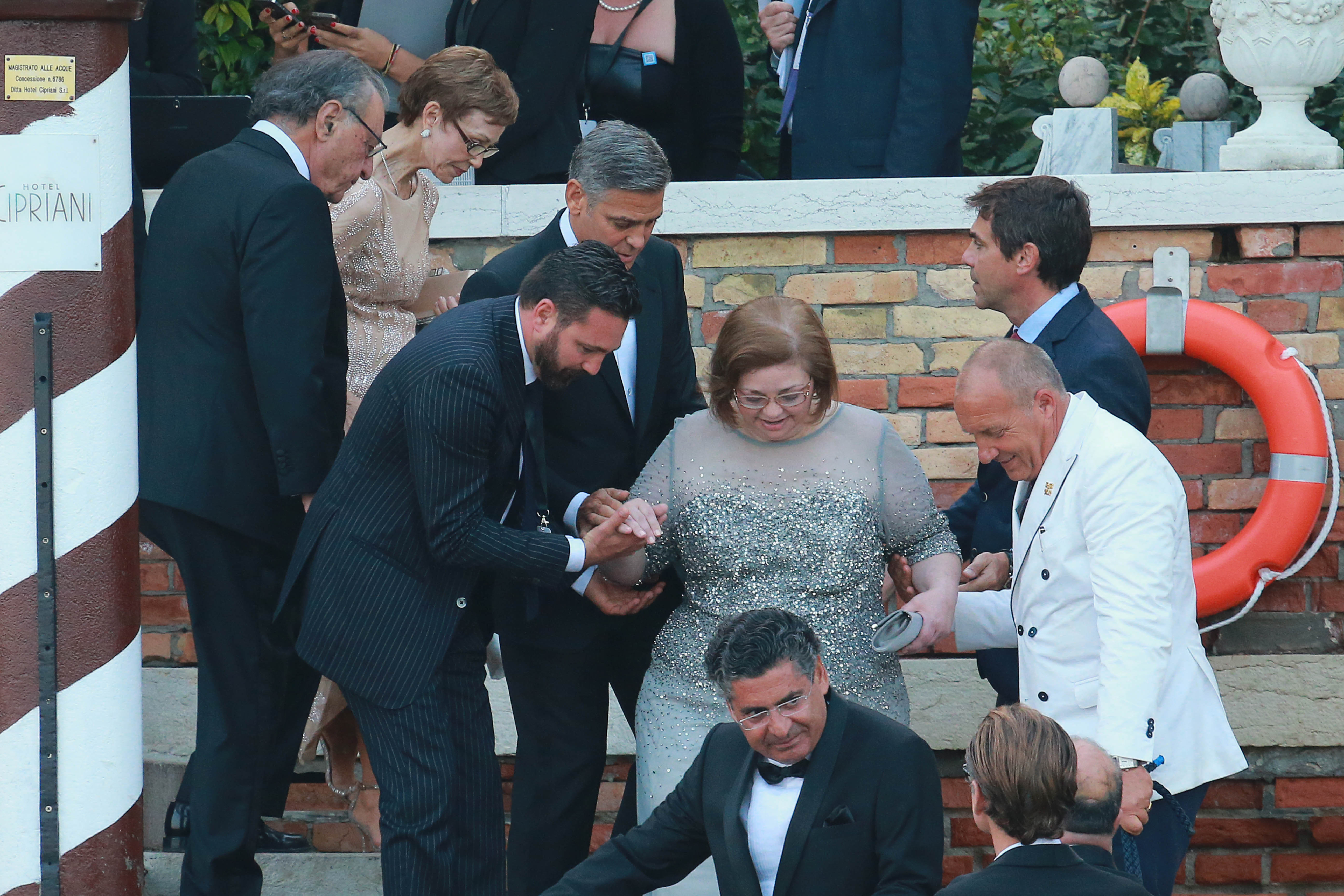 Ada Zeidler is escorted by family members down the steps outside Hotel Cipriani in Venice during George and Amal Clooney's wedding weekend in 2014 | Source: Getty Images