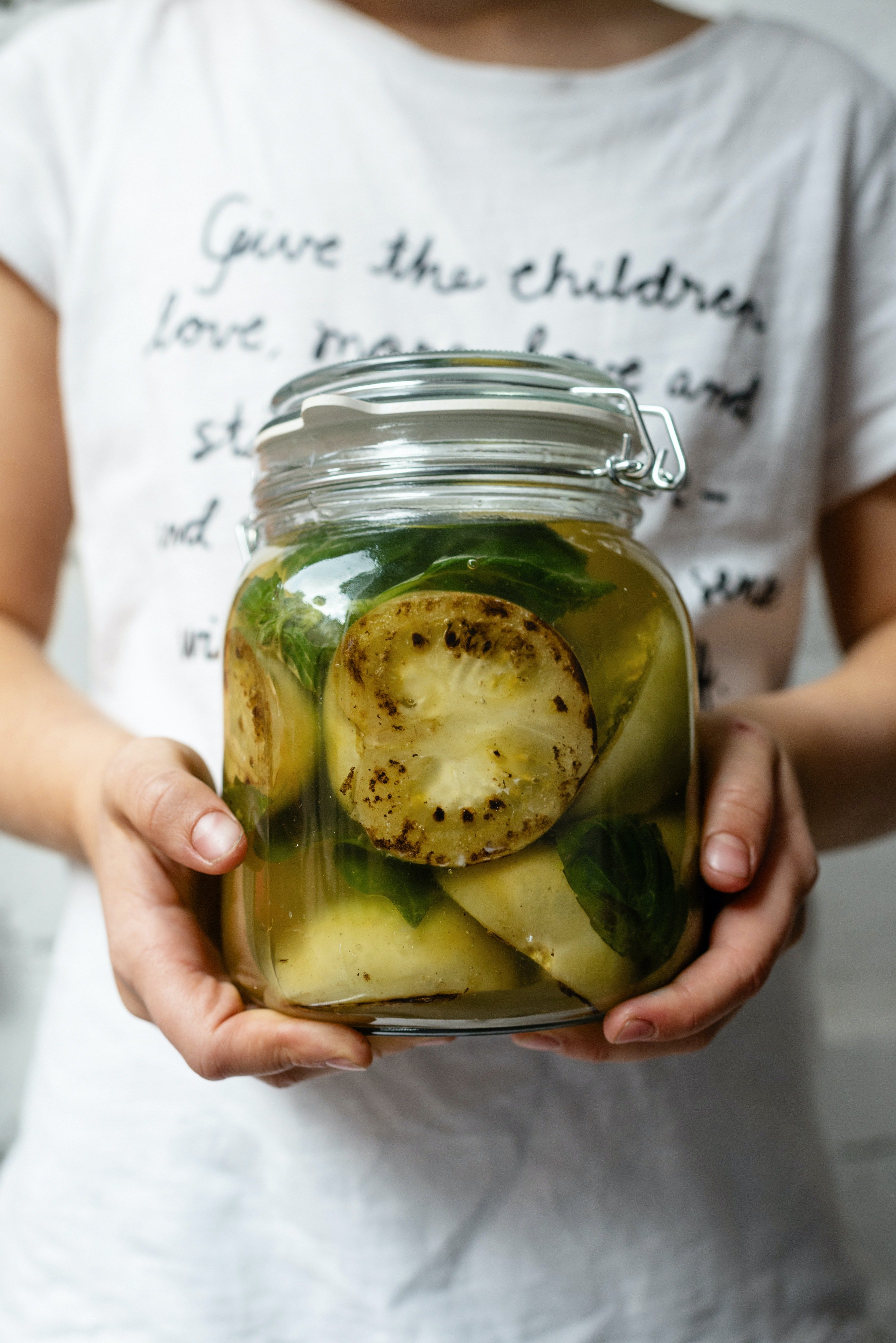 Pictured - A woman holding a jar of pickled zucchini | Source: Pexels 