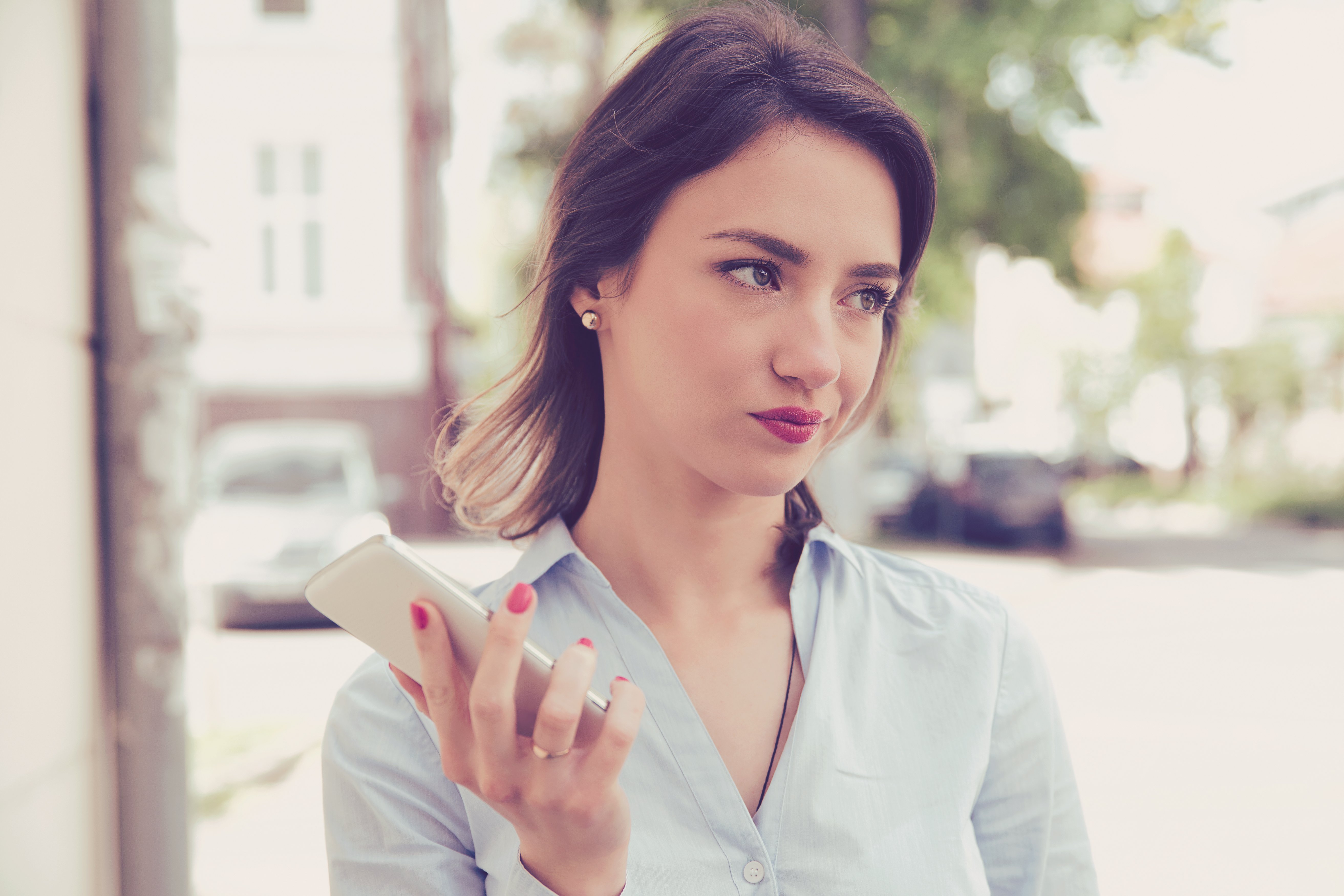 Mujer frustrada con teléfono en mano. | Fuente: Shutterstock