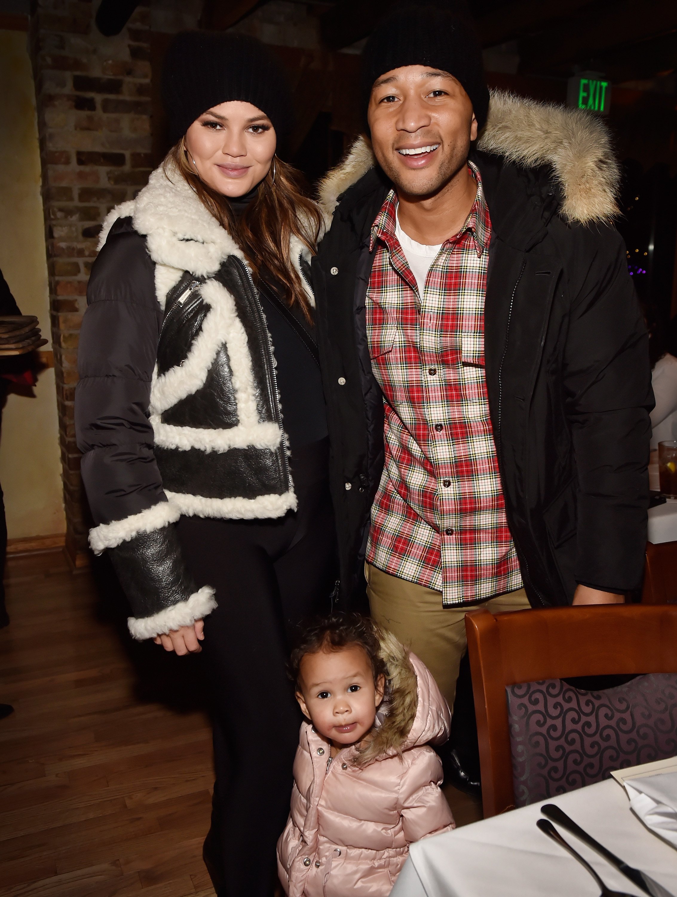 Chrissy Teigen (L) and her husband, recording artist John Legend pose with their daughter Luna Simone Stephens at the "Monster" dinner film reception presented by the RAND Luxury Escape at Grappa during the 2018 Sundance Film Festival on January 21, 2018 in Park City, Utah | Source: Getty Images