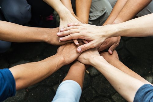 Personas uniendo sus manos en gesto de solidaridad. | Foto: Shutterstock