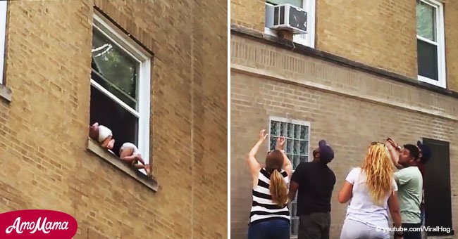 Two babies dangle out of window while passers-by get ready to catch them in terrifying video