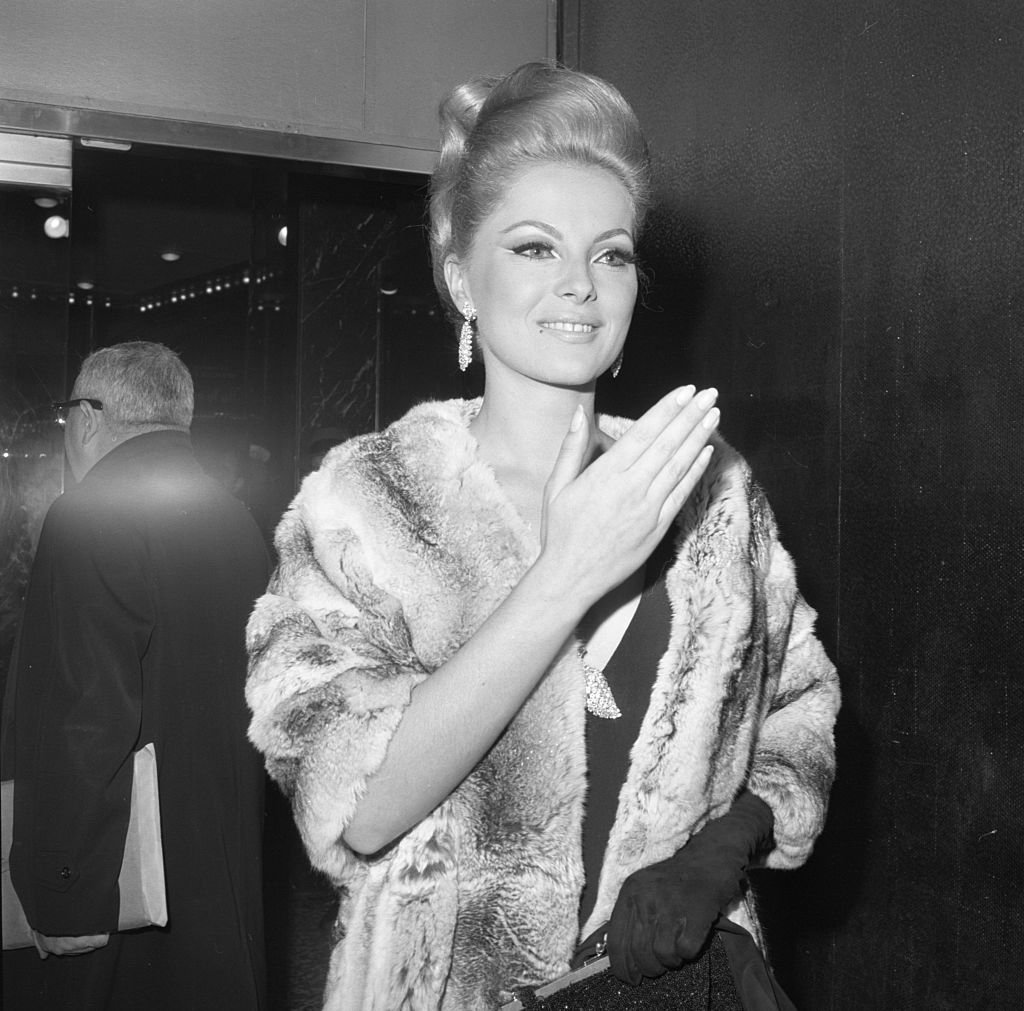 Virna Lisi arrive à la première de son film "Comment assassiner votre femme", pose pour les photographes à son arrivée au El Morocco Night Club à New York. | Photo : Getty Images