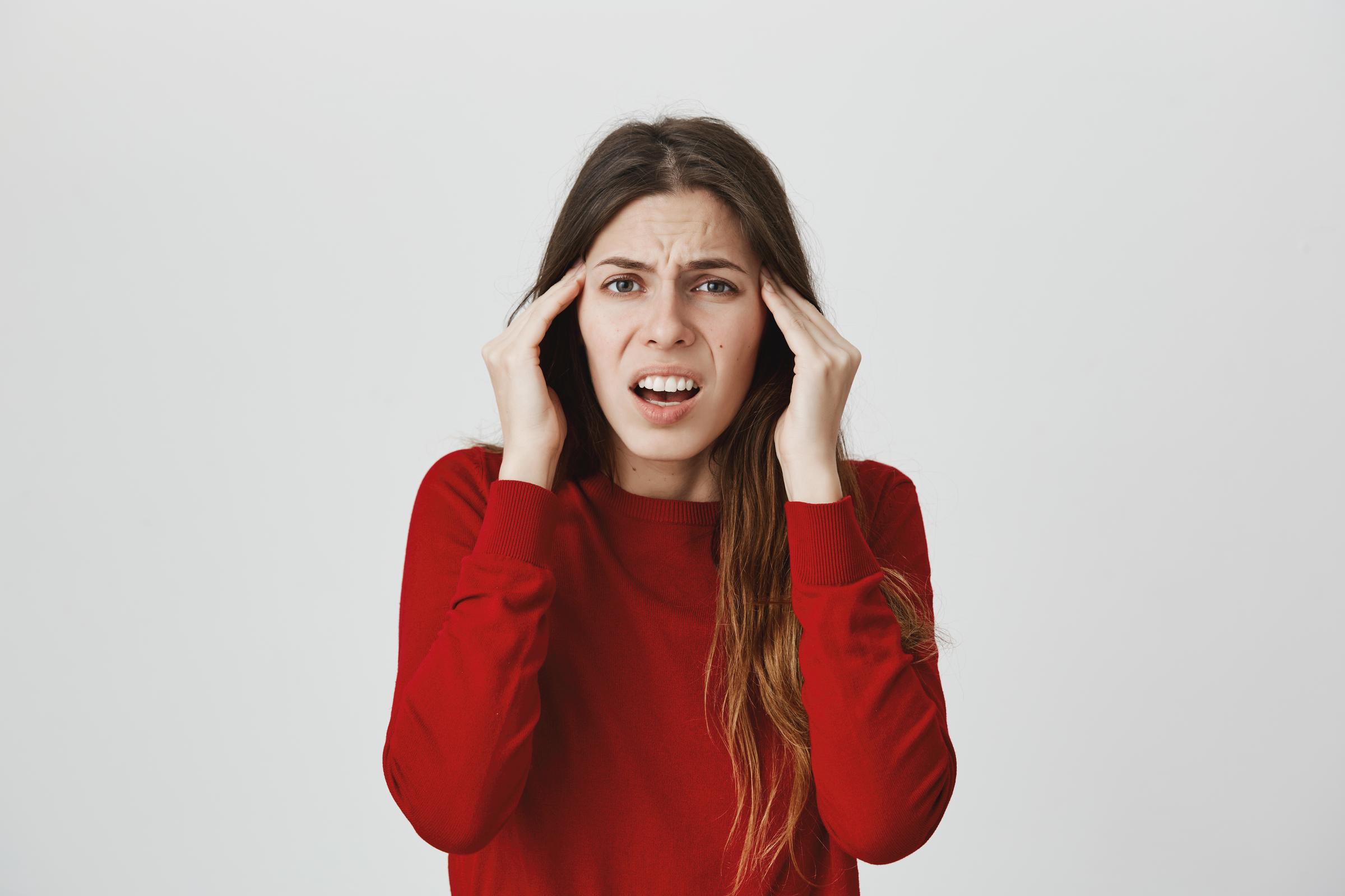 A furious woman holding her head | Source: Pexels