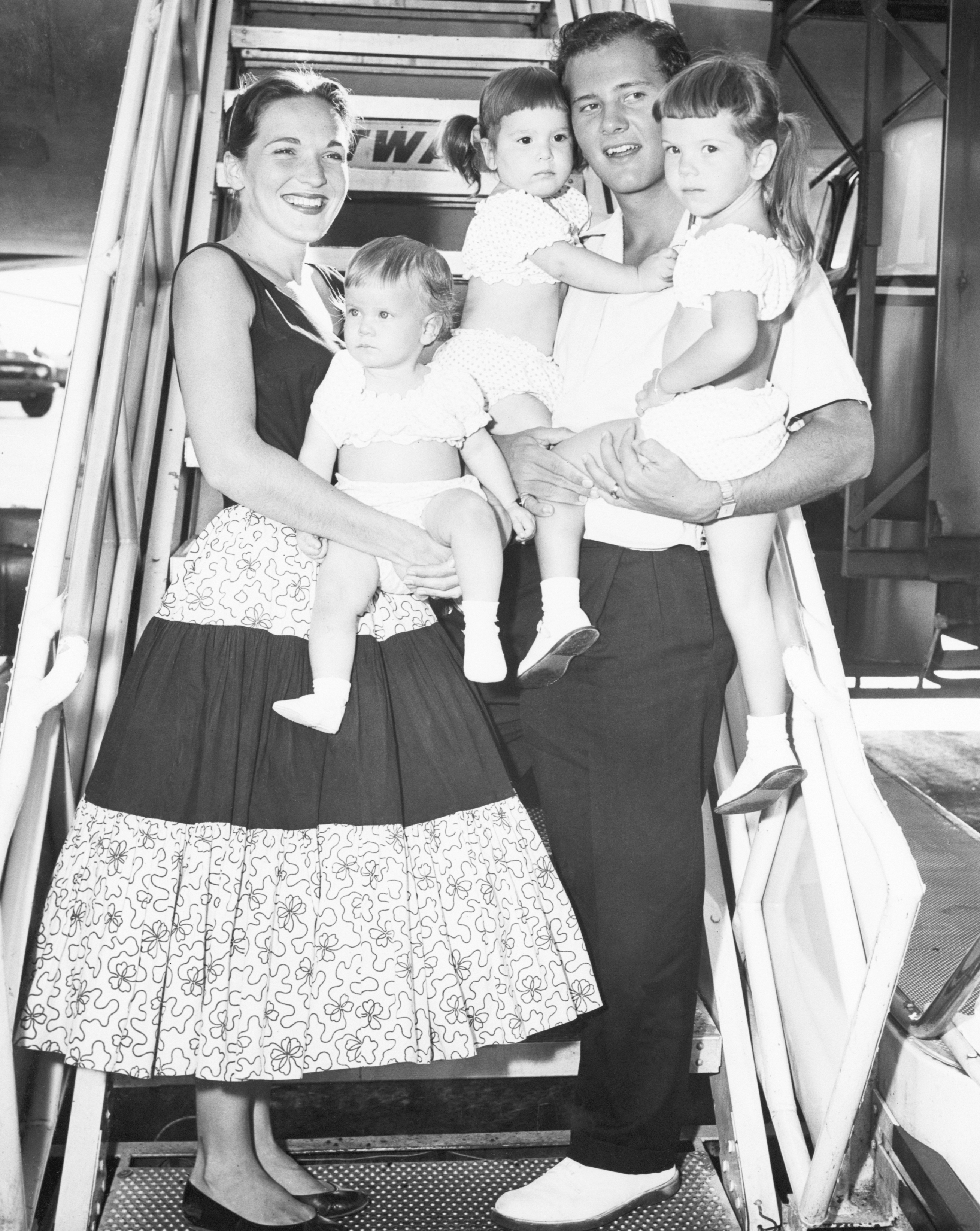 Pat and Shirley Boone with three of their daughters boarding a plane in 1957 | Source: Getty Images
