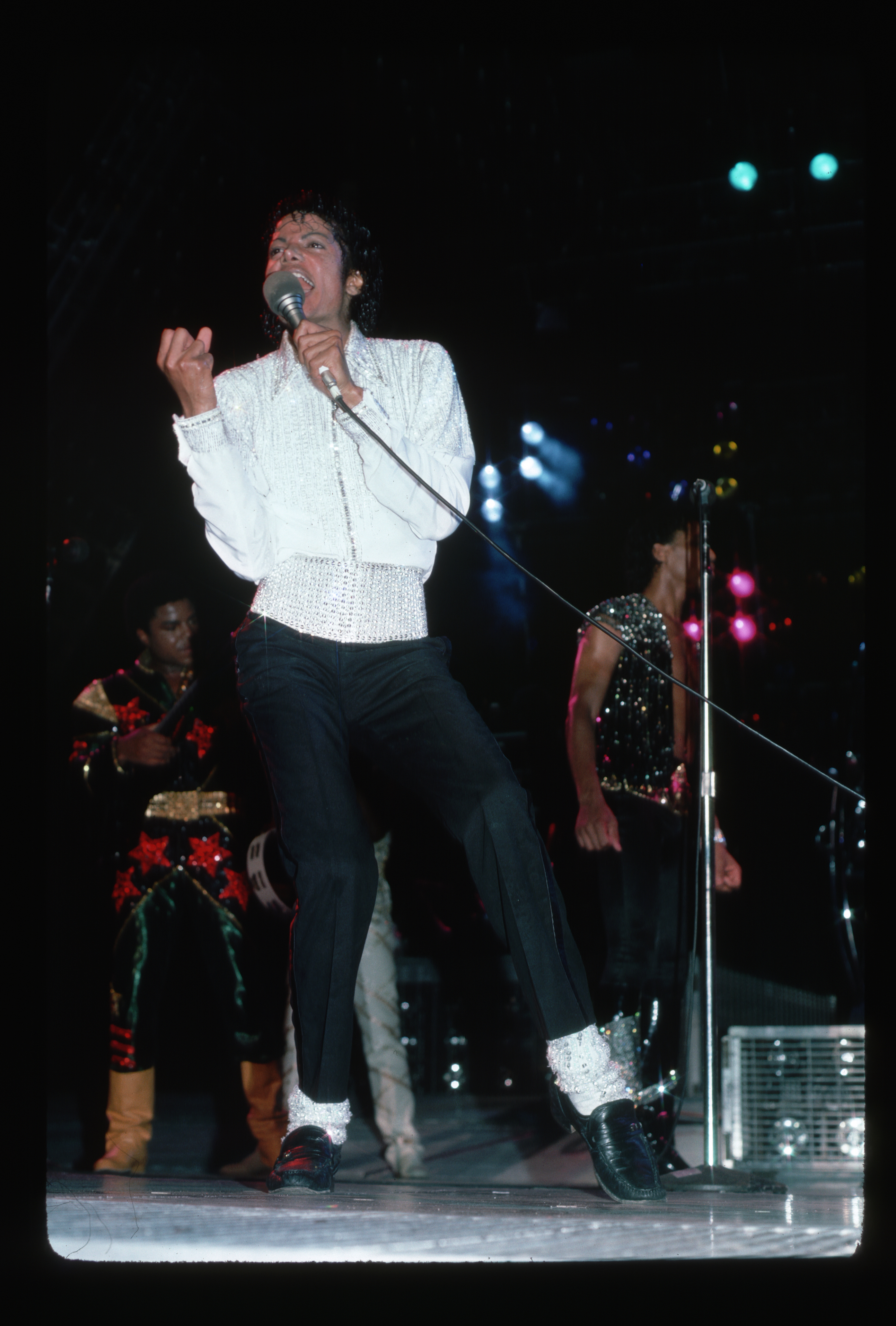 Michael Jackson performs on stage sporting a white sequined shirt and matching socks in 1994 | Source: Getty Images