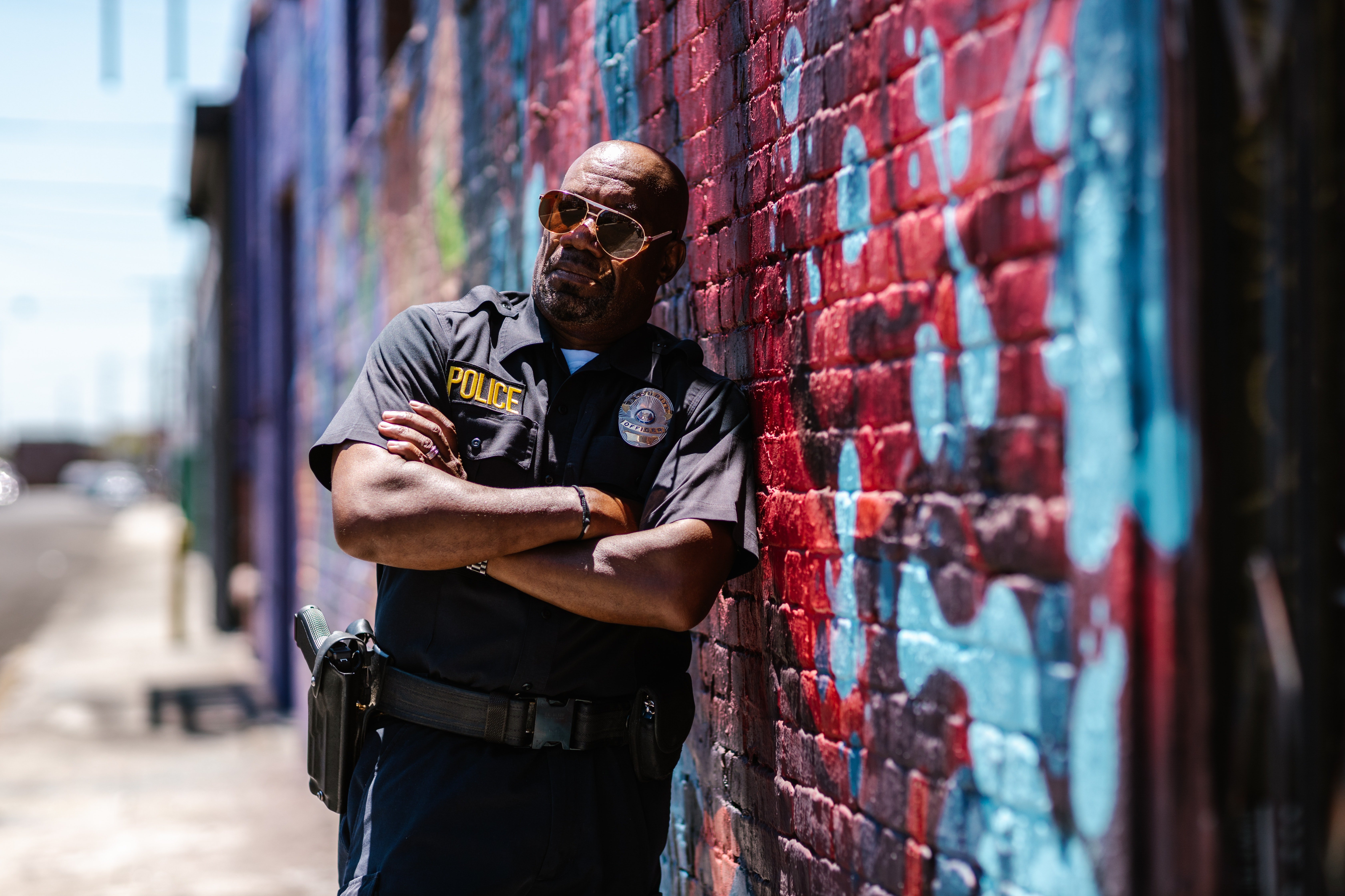Policía recostado de una pared. | Foto: Pexels