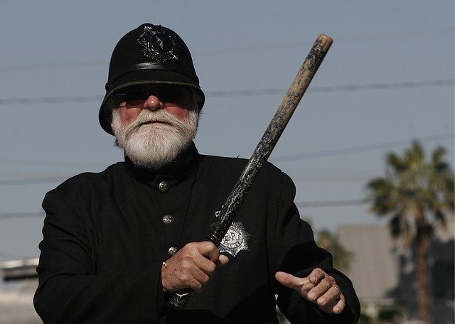 Police officer holds a baton | Photo: Pixabay