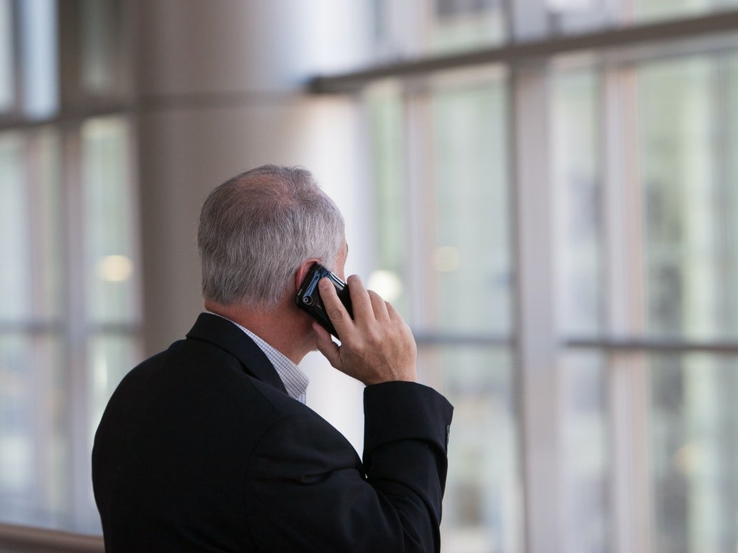 A veteran on his phone after a memorial | Photo: Pexels