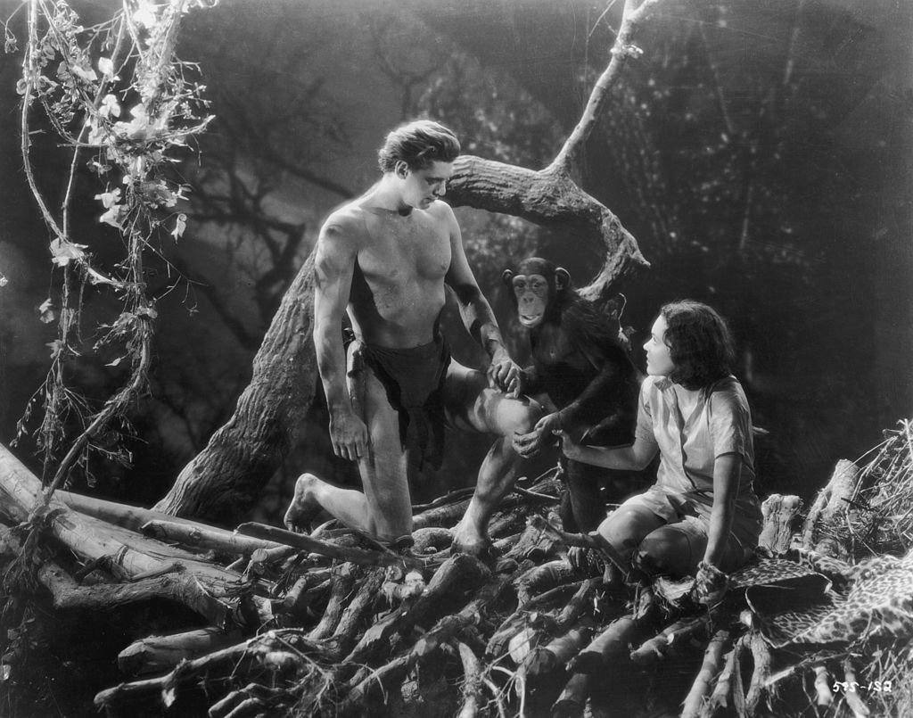 Johnny Weissmuller como Tarzán y Maureen O'Sullivan como Jane, tomados de la mano con 'Cheetah' el chimpancé. | Foto: Getty Images