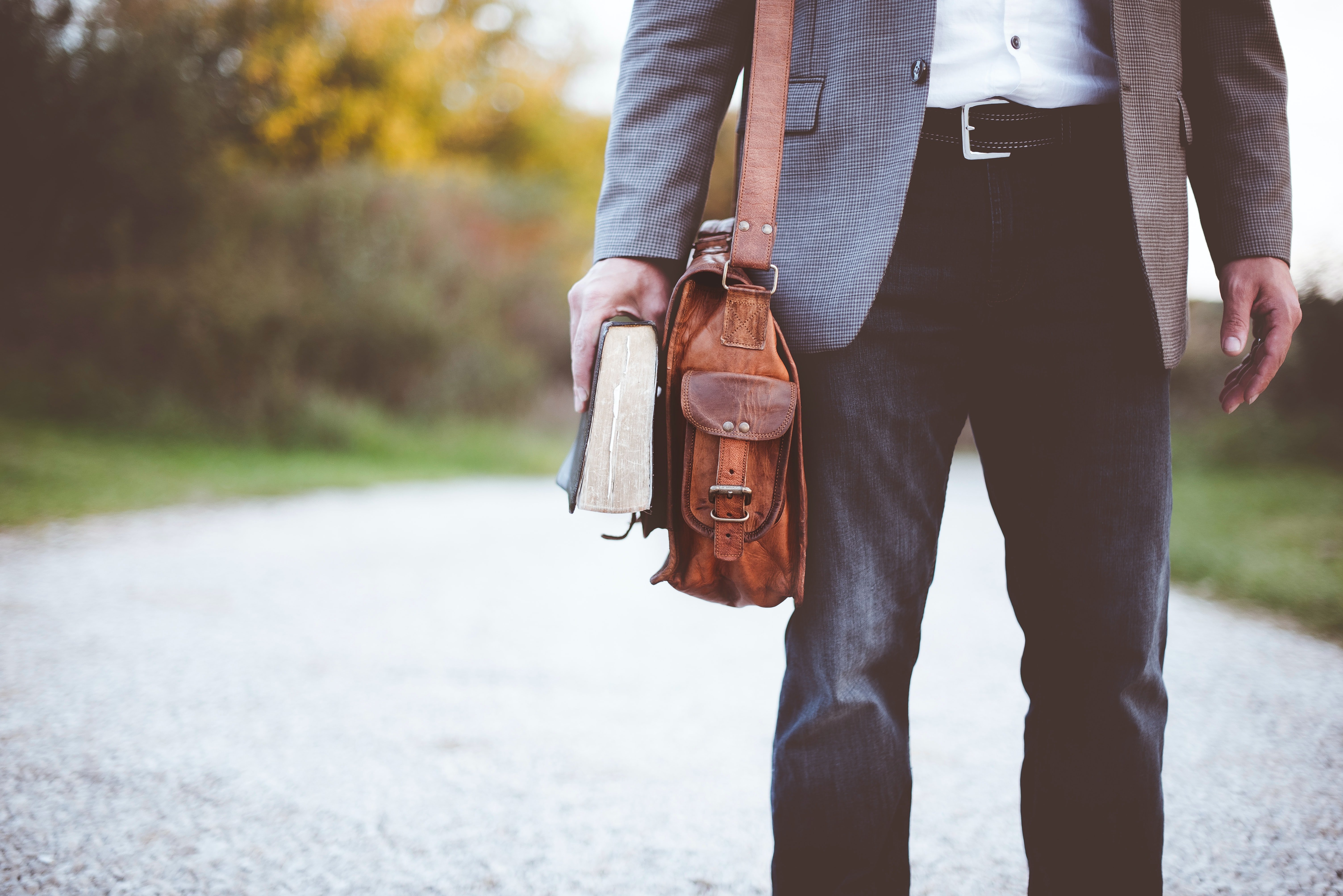 Un hombre con un maletín y un libro en su mano. | Foto: Unsplash