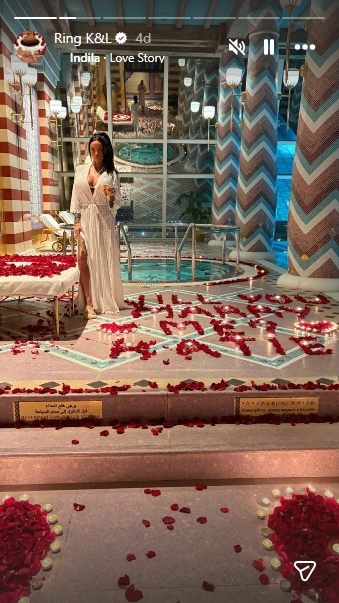 Katie Price poses in a rose-petal-filled setting where the words "Will You Marry Me" are spelled out beside a heart-shaped candle display during the couple's lavish engagement setup. | Source: Instagram/wesleeeandrews