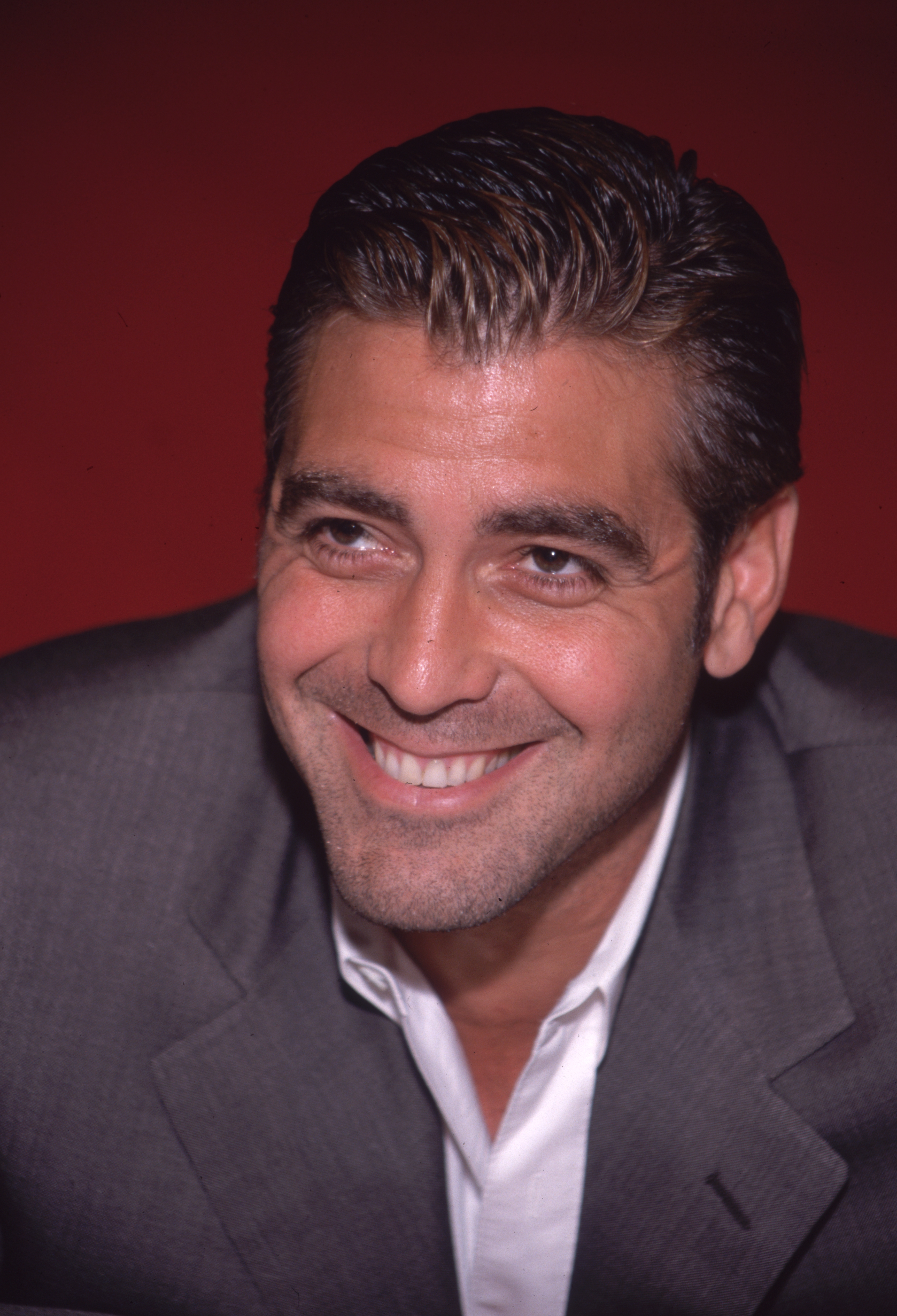 A studio headshot captured actor George Clooney with a beaming smile on June 9, 1998. | Source: Getty Images
