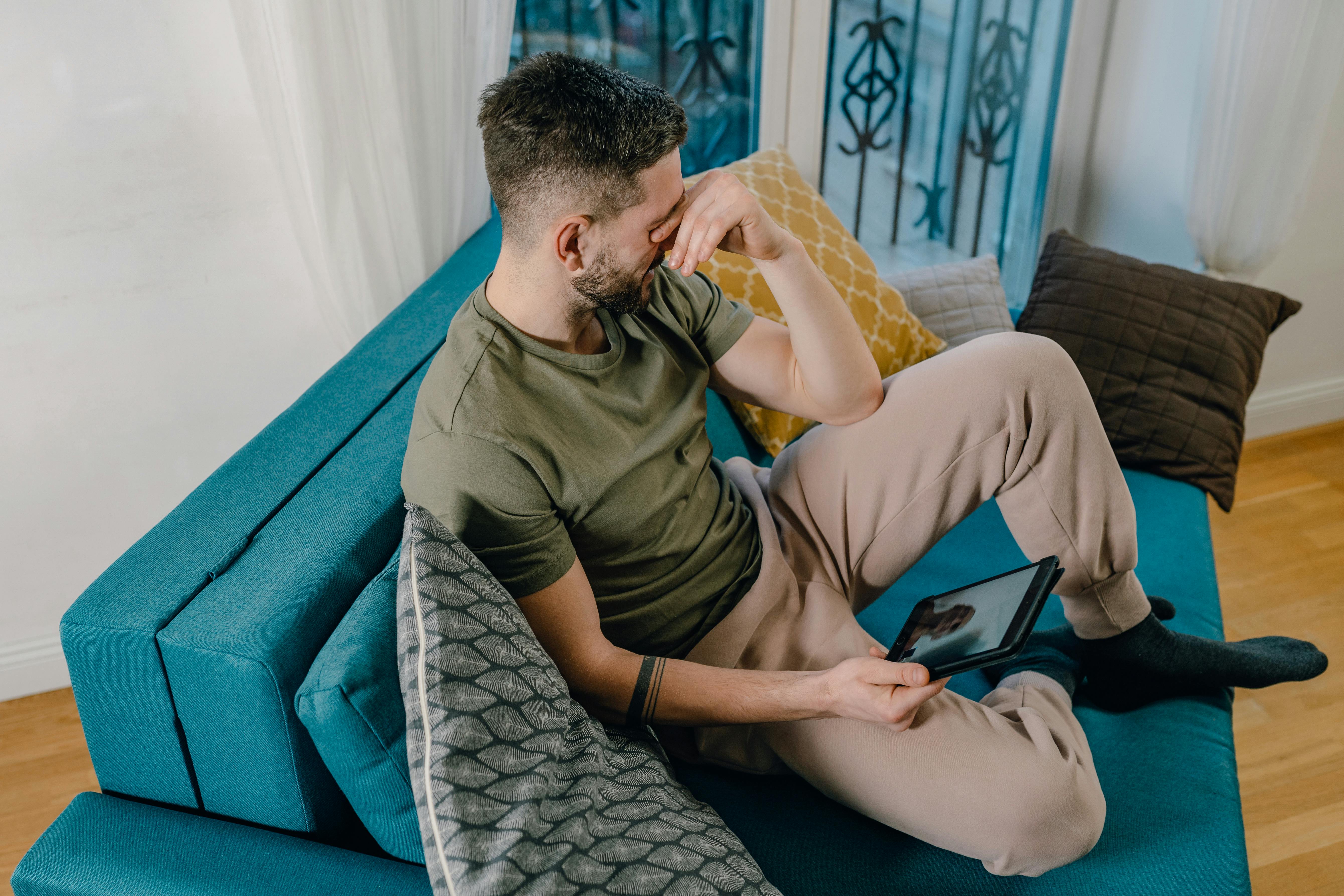 A man crying while sitting on a sofa | Source: Pexels