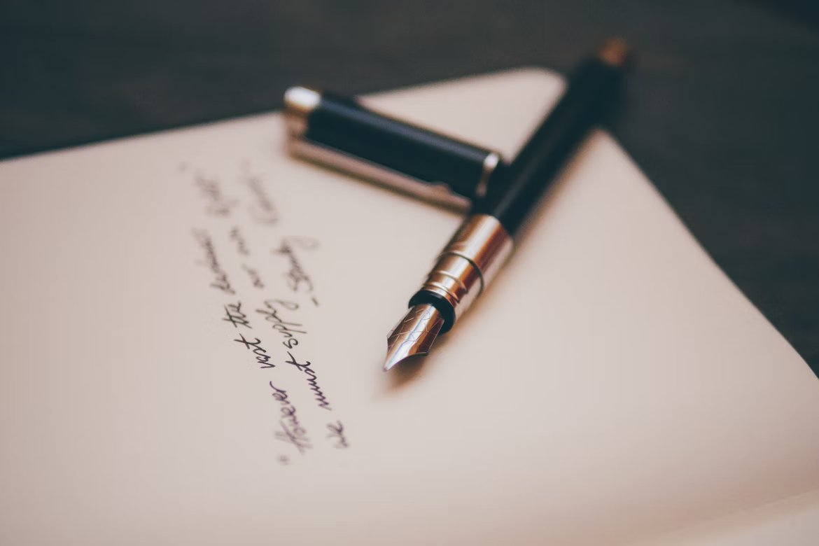 Una pluma fuente sobre un documento escrito a mano. | Foto: Unsplash